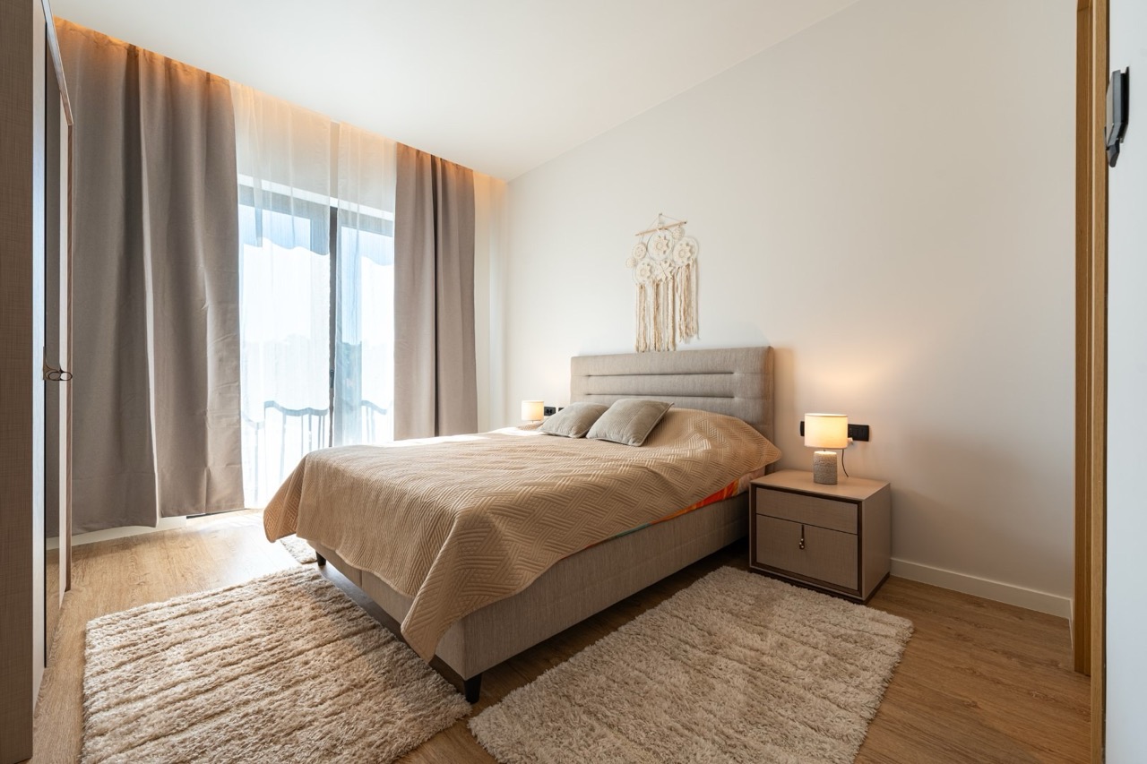 Modern bedroom in an apartment in Porto Montenegro, Tivat, Montenegro: double bed, panoramic window, and decor.