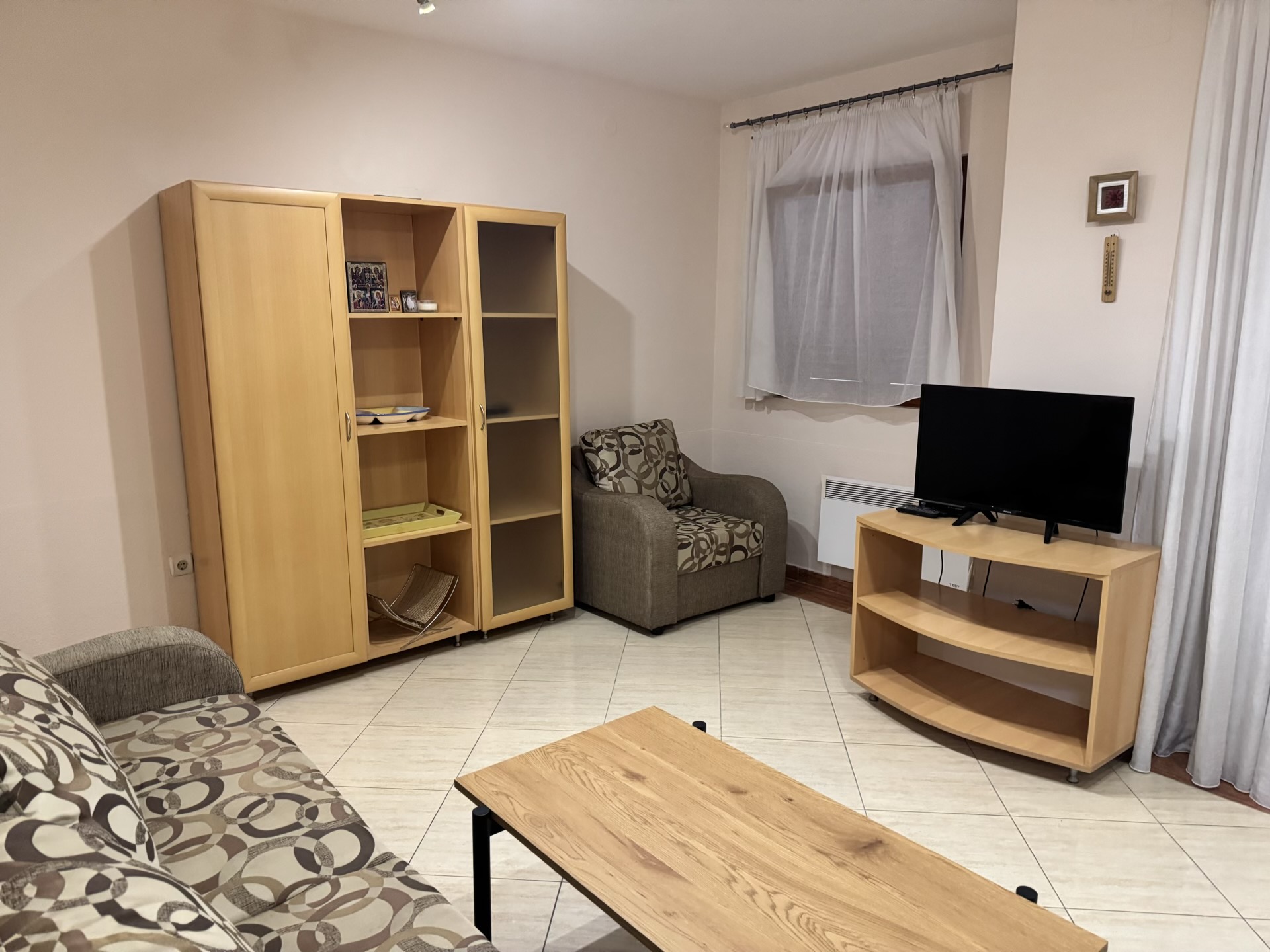 Cozy living room with light wood furniture in an apartment for sale in Budva, Montenegro.