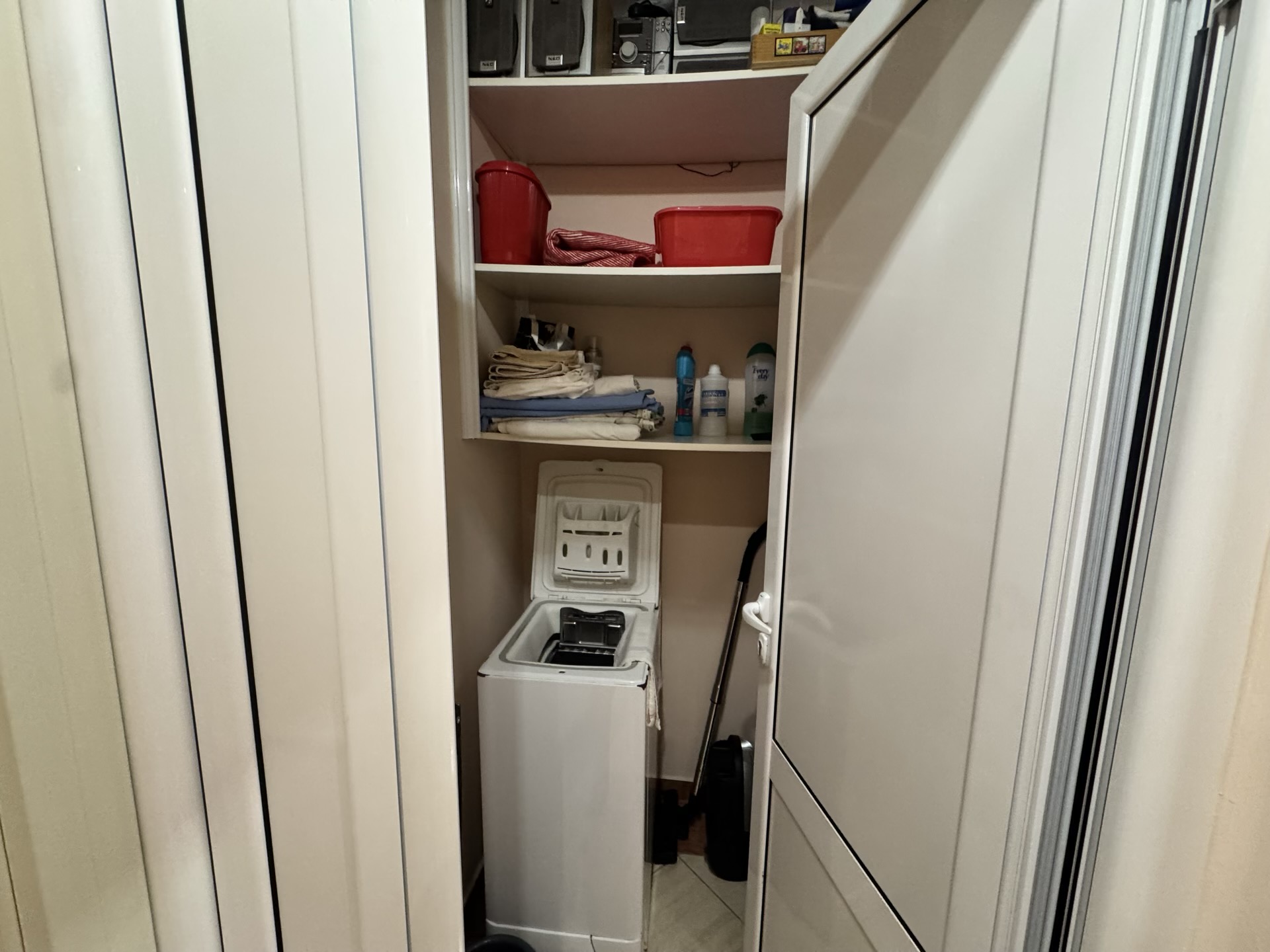 Utility nook with a top-loading washing machine and storage shelves in an apartment, Budva, Montenegro