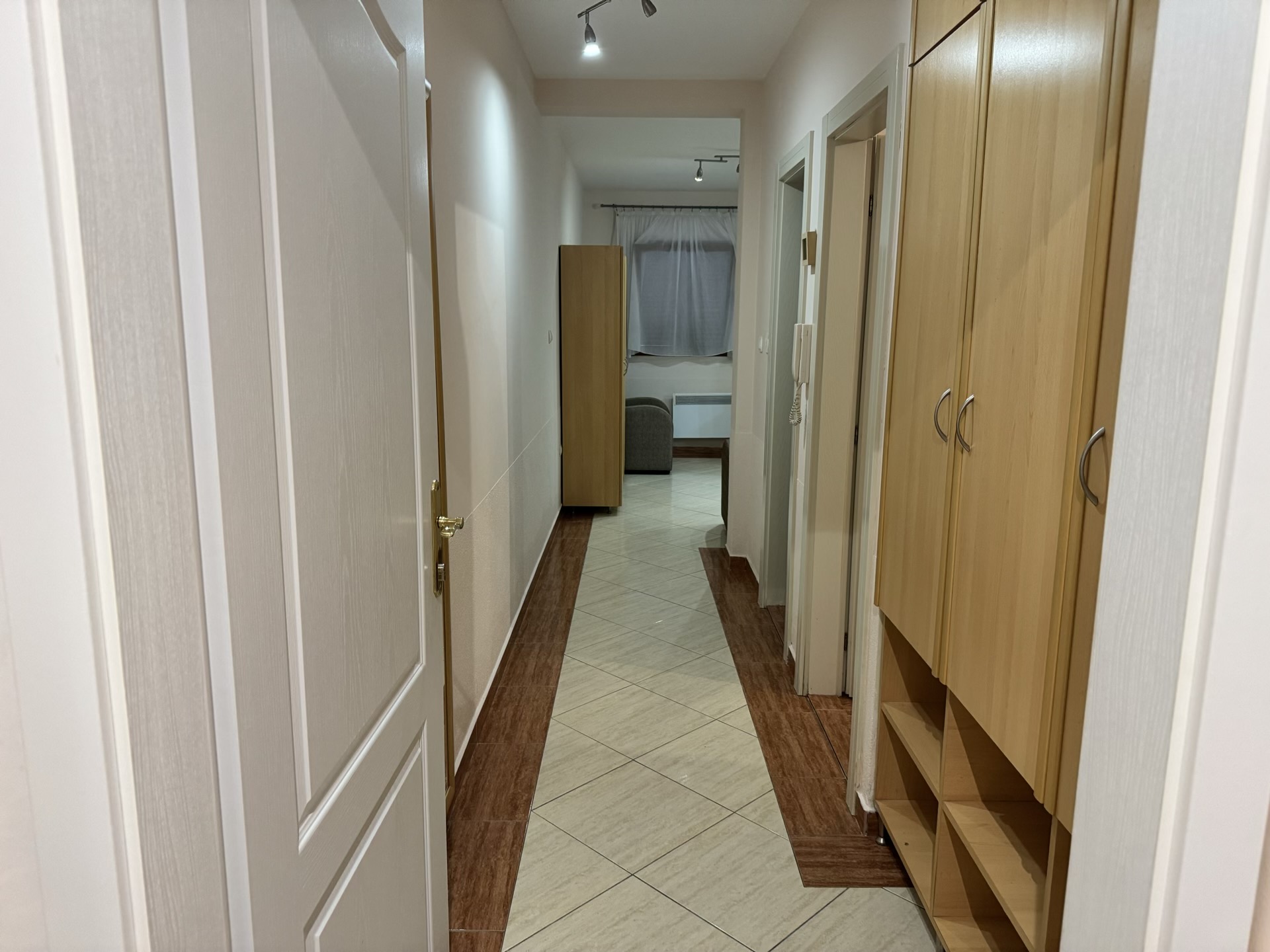 Bright hallway in an apartment in Budva, Montenegro: built-in wardrobe, tiled floor, and interior doors.