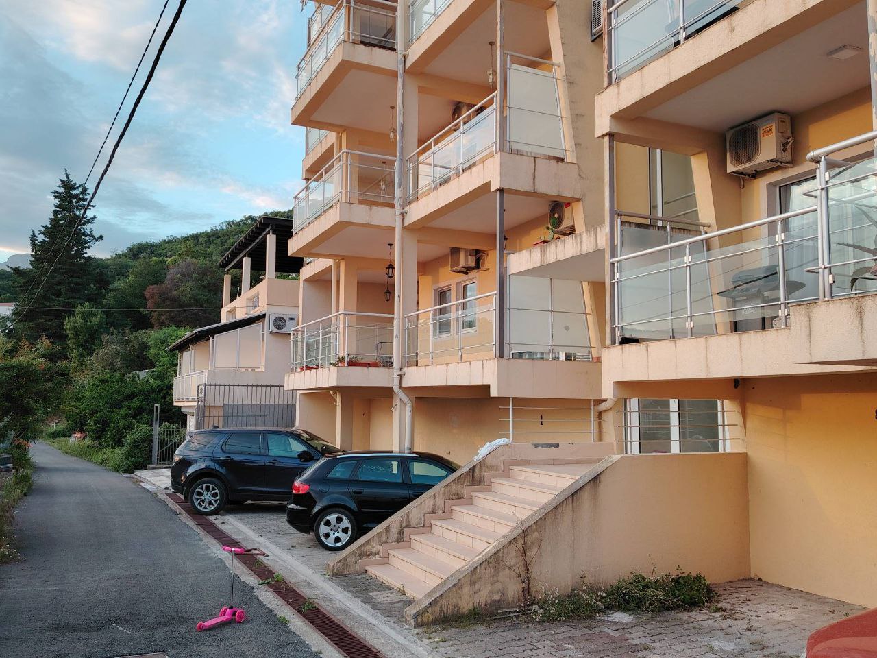 Facade of a residential building with balconies and parking in Sutomore, Montenegro: exterior view of a multi-apartment property.