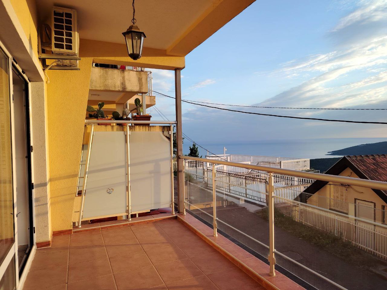 Spacious balcony with panoramic sea view in an apartment, Seoce, Montenegro: tiled floor and glass railing.