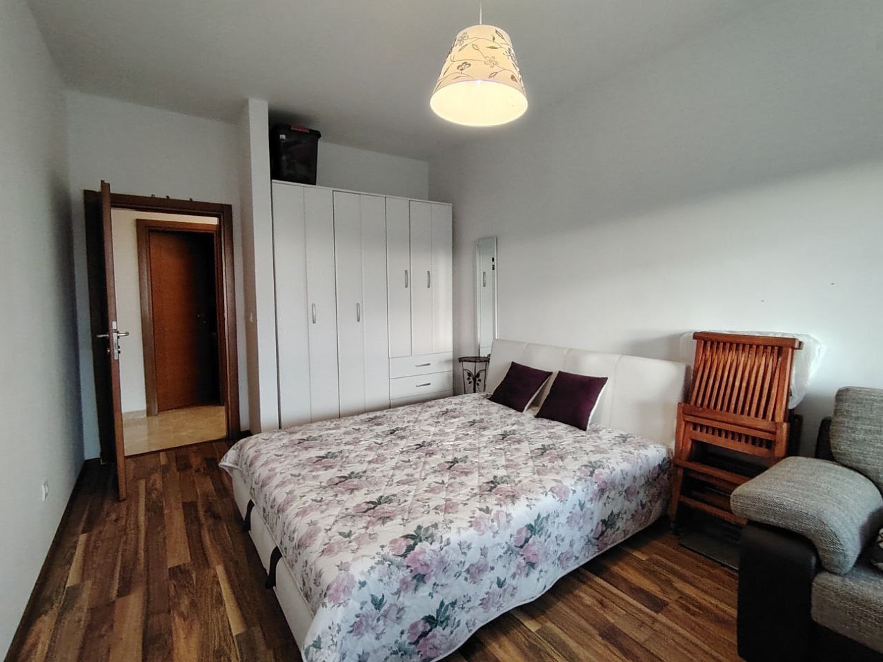 Bedroom in an apartment in Sutomore, Montenegro: a double bed, white wardrobe, wooden floor, and a cozy interior.