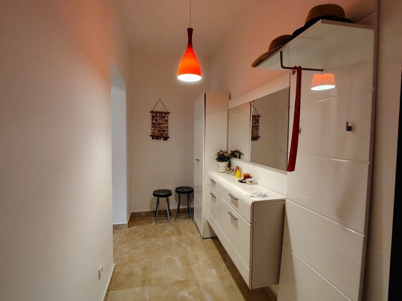 Bright entryway with white furniture and a mirror in an apartment, Seoc, Montenegro. Modern interior with bright lighting.