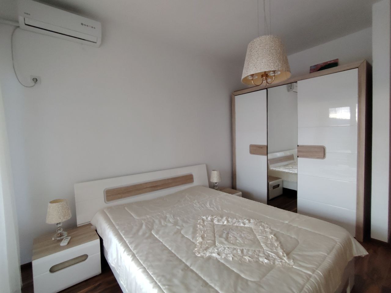 Bright bedroom with a double bed and mirrored wardrobe in an apartment, Sutomore, Montenegro.