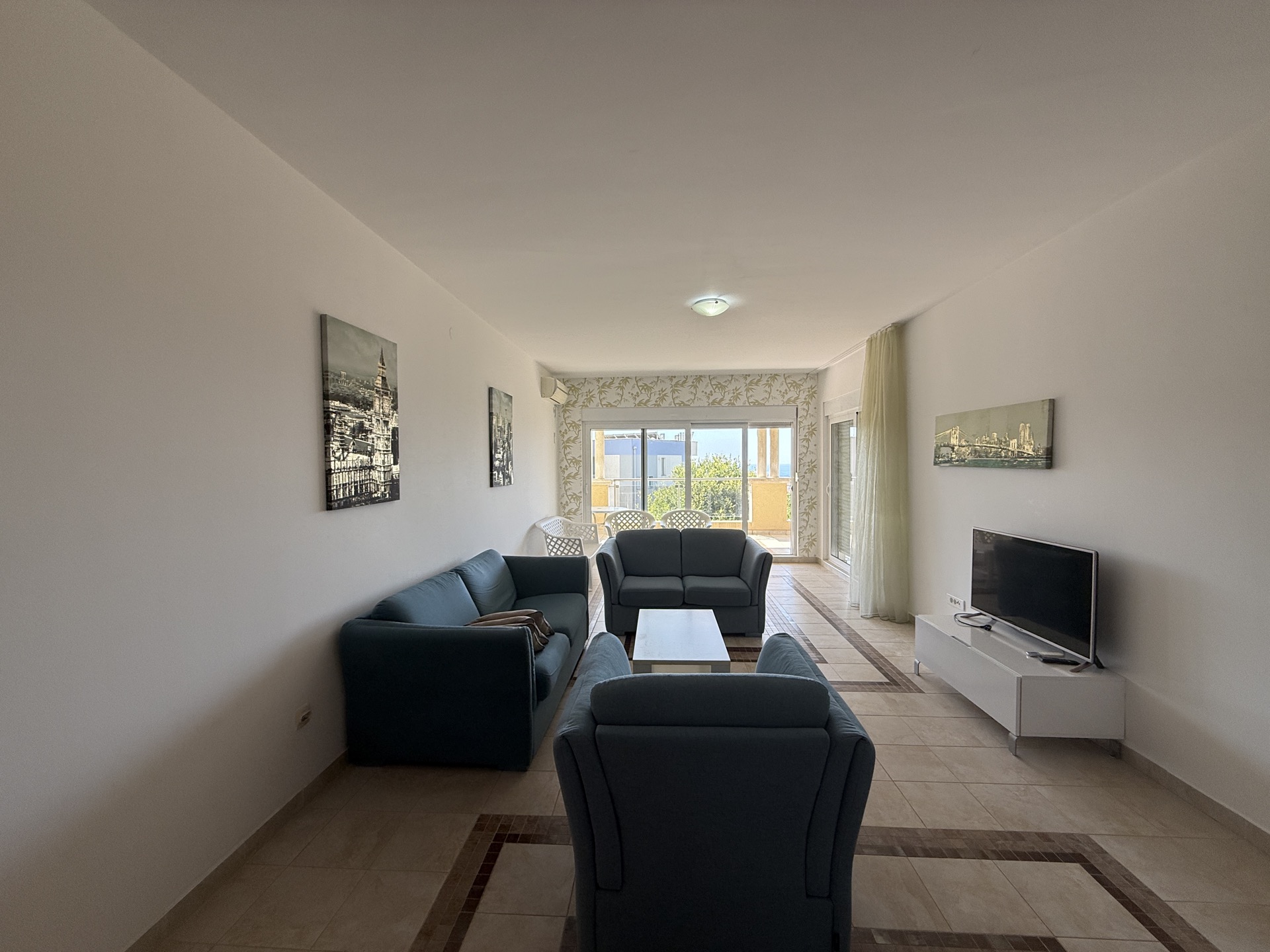 Bright living room with blue sofas in an apartment in Budva, Montenegro, with access to a terrace and sea view.
