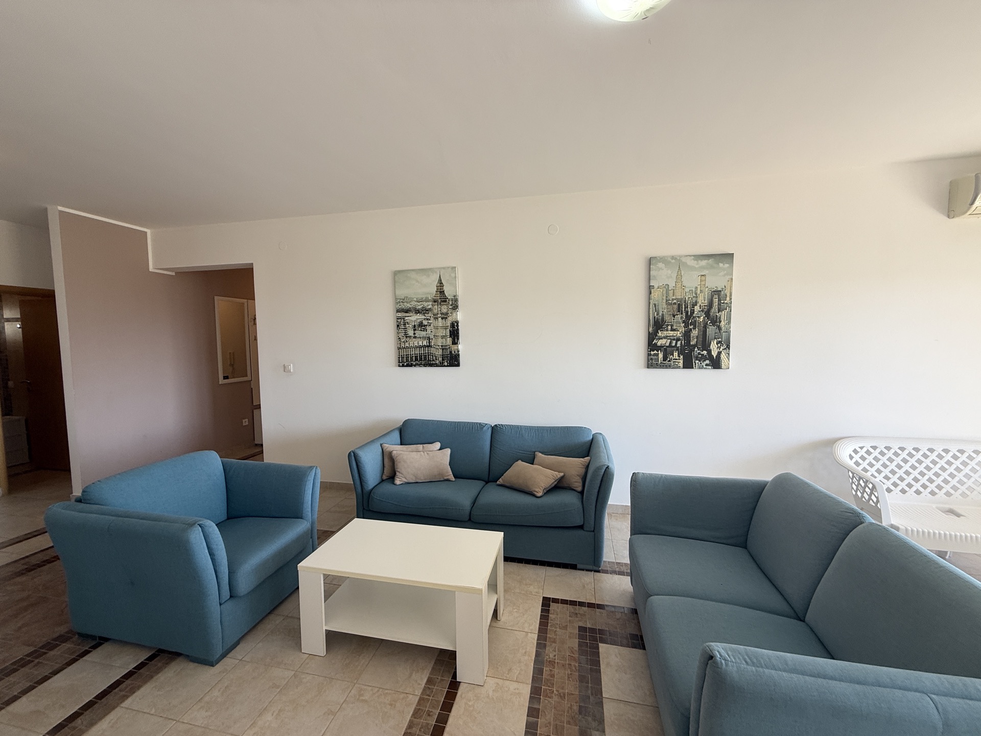 Bright living room with blue sofas and a coffee table in an apartment for sale, Budva, Montenegro.
