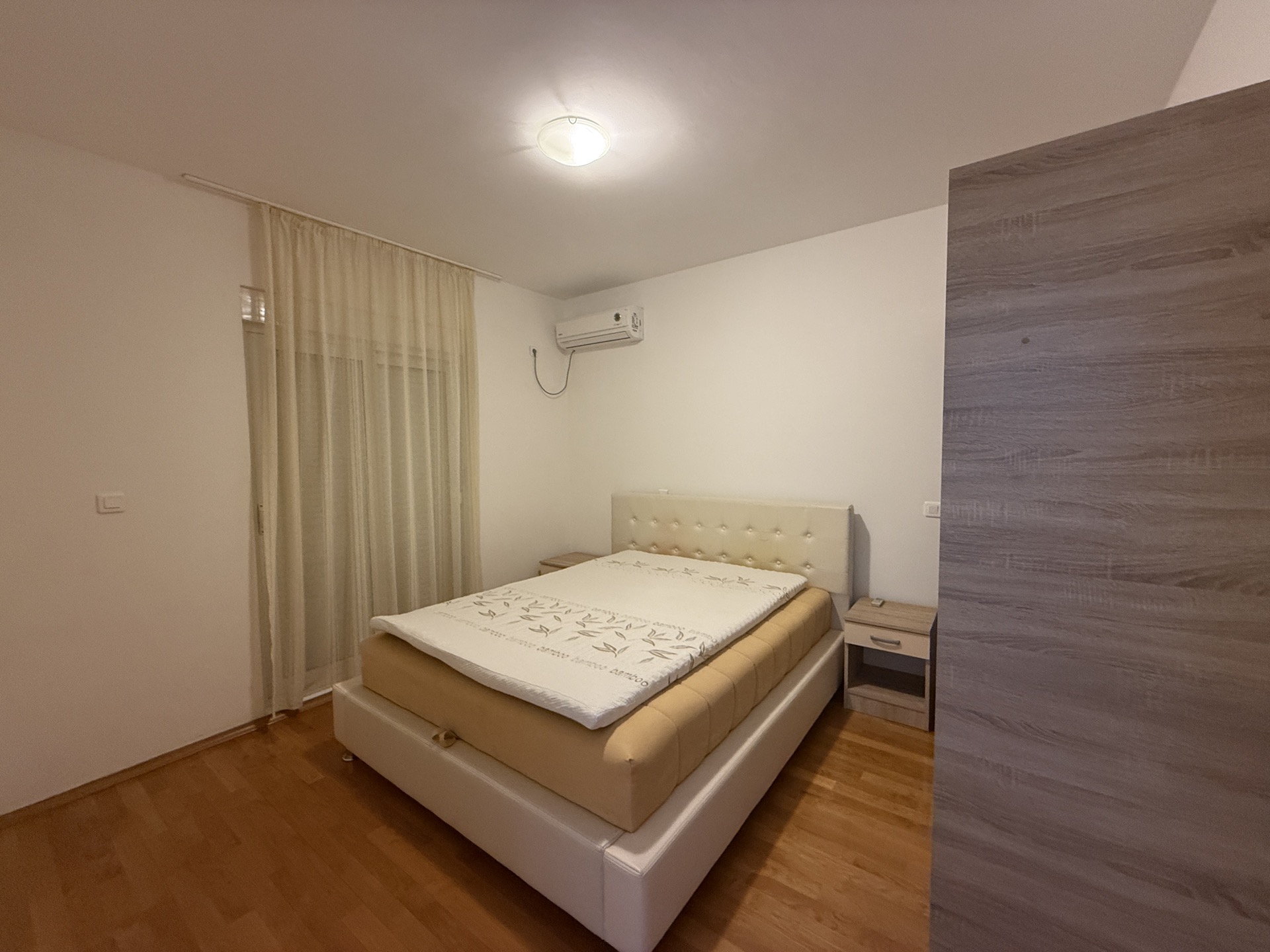 Cozy bedroom with a double bed and air conditioning in an apartment for sale, Budva, Montenegro.