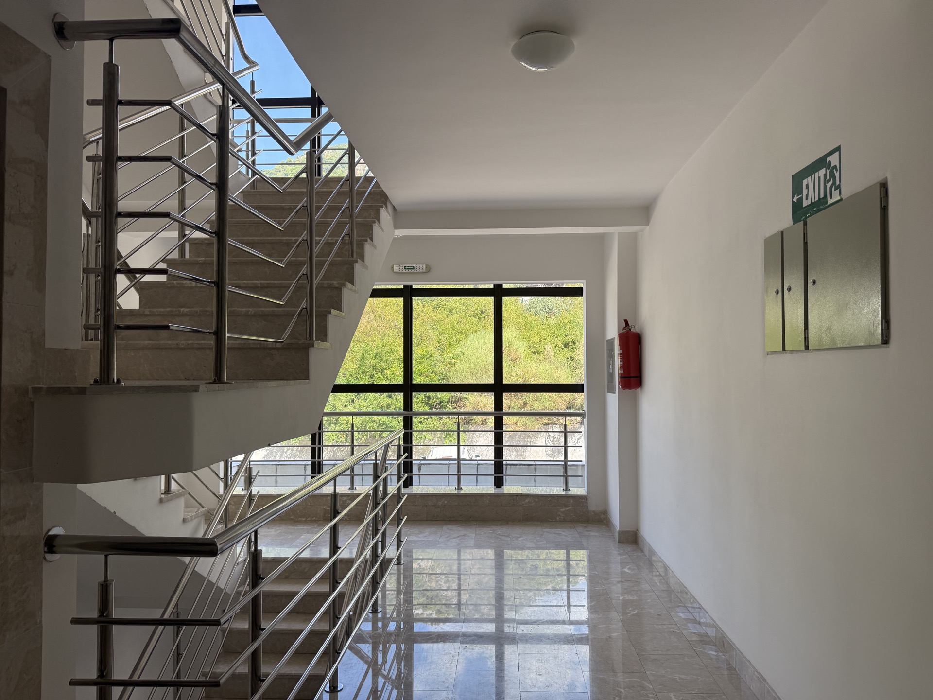 Bright stairwell with a marble floor and panoramic window in a residential complex, Budva, Montenegro.