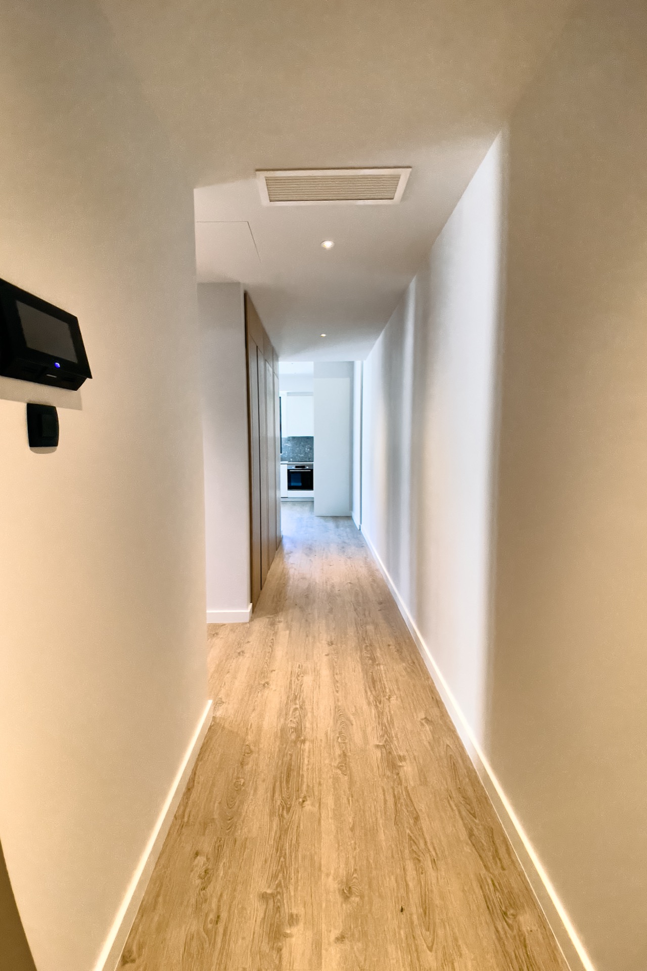 Bright hallway in a modern apartment in Porto Montenegro, Tivat, Montenegro, with wooden flooring and built-in furniture.