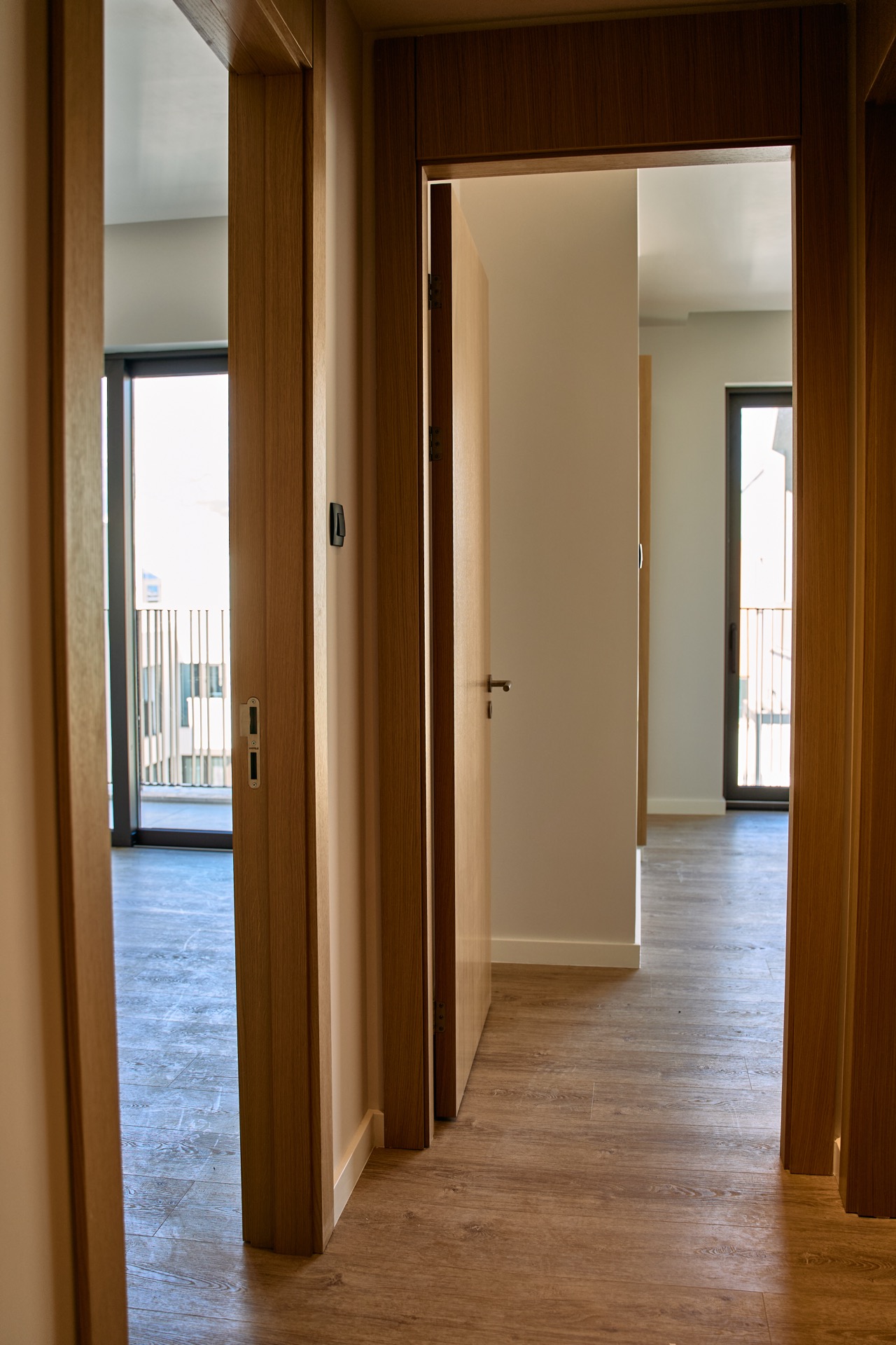 Modern apartment interior in Porto Montenegro, Tivat: a bright hallway with wooden doors and access to the balcony.