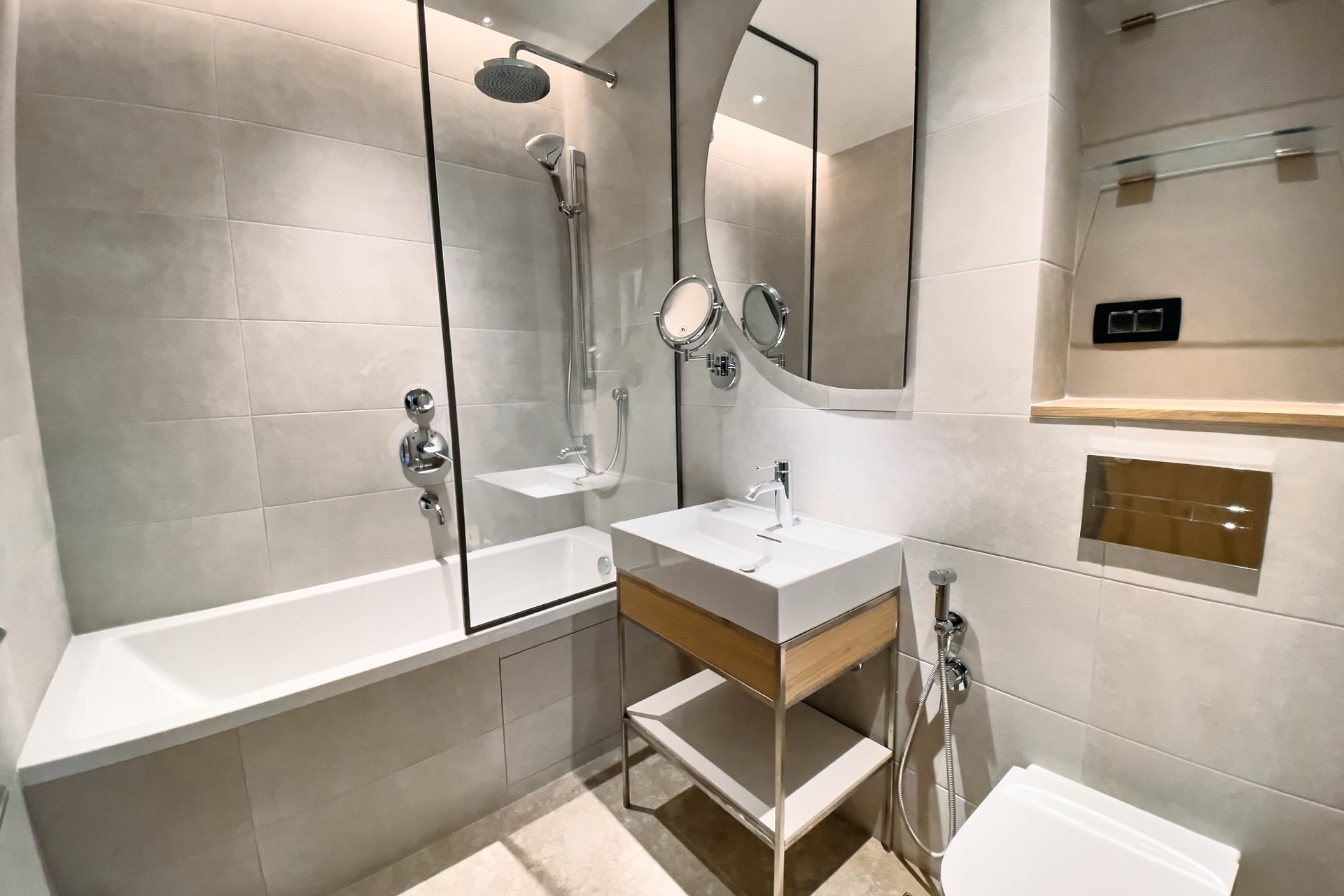 Modern bathroom in an apartment in Porto Montenegro, Tivat, Montenegro: bathtub, glass partition, and stylish furniture.