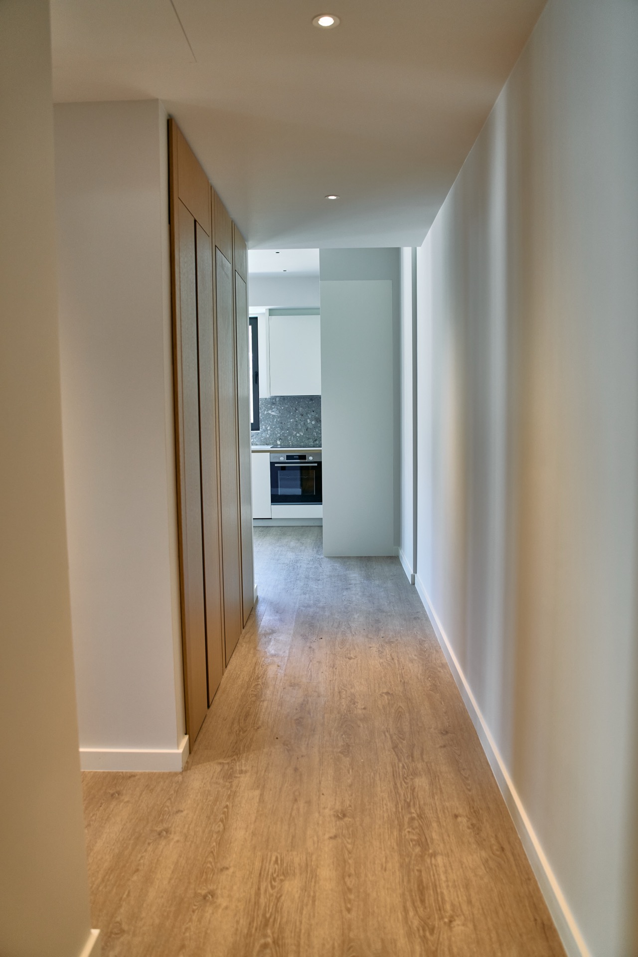 Hallway with wooden cabinets and a view of the modern kitchen in an apartment in Porto Montenegro, Tivat, Montenegro.
