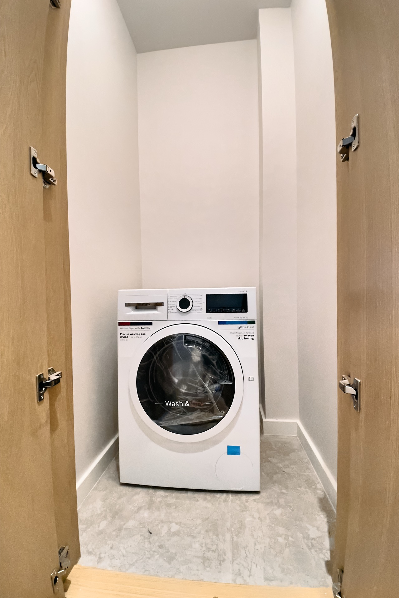 Bosch washing machine in a niche with wooden doors in an apartment, Porto Montenegro, Tivat, Montenegro.