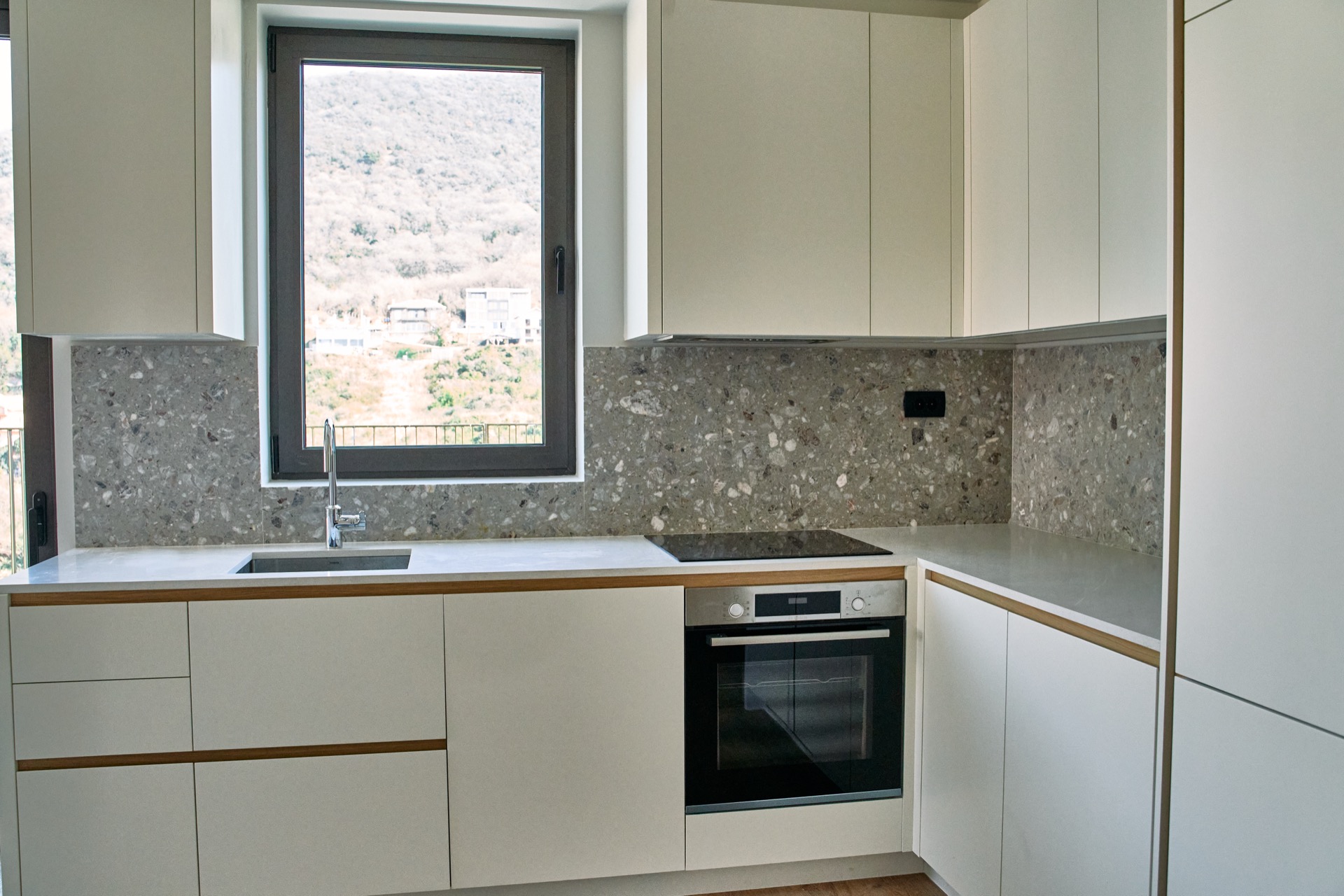 Modern kitchen with a stone backsplash and mountain views in an apartment in Porto Montenegro, Tivat, Montenegro.