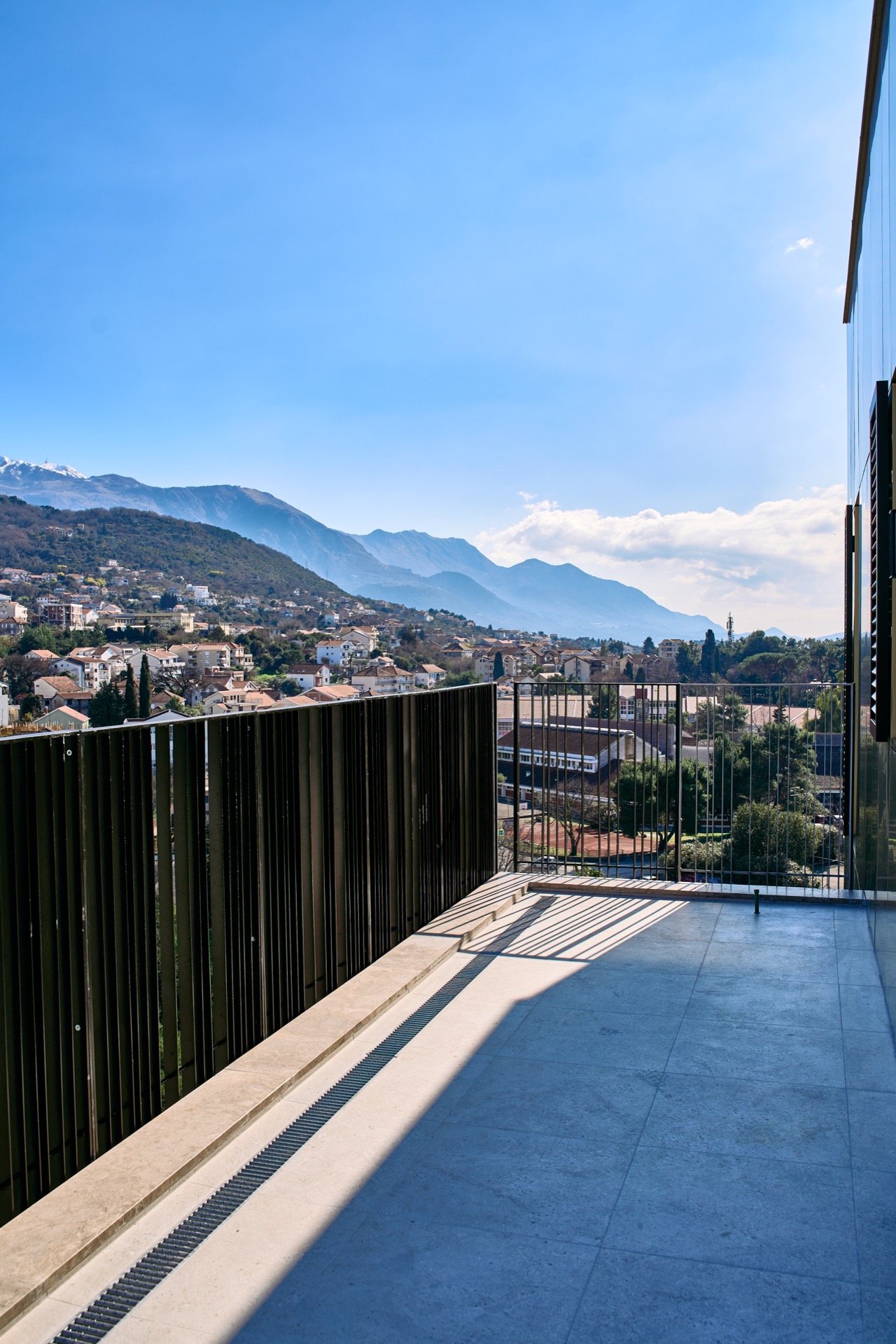 Spacious balcony with panoramic views of the mountains and the city of Tivat, Porto Montenegro, Montenegro. Modern finishes.