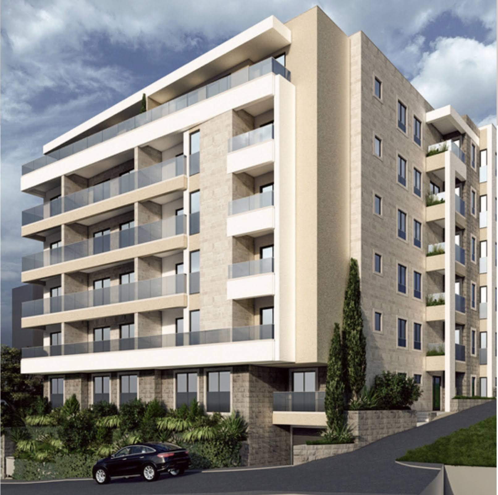 Modern residential complex with terraces in Bečići, Montenegro: stone facade, panoramic glazing, and underground parking.