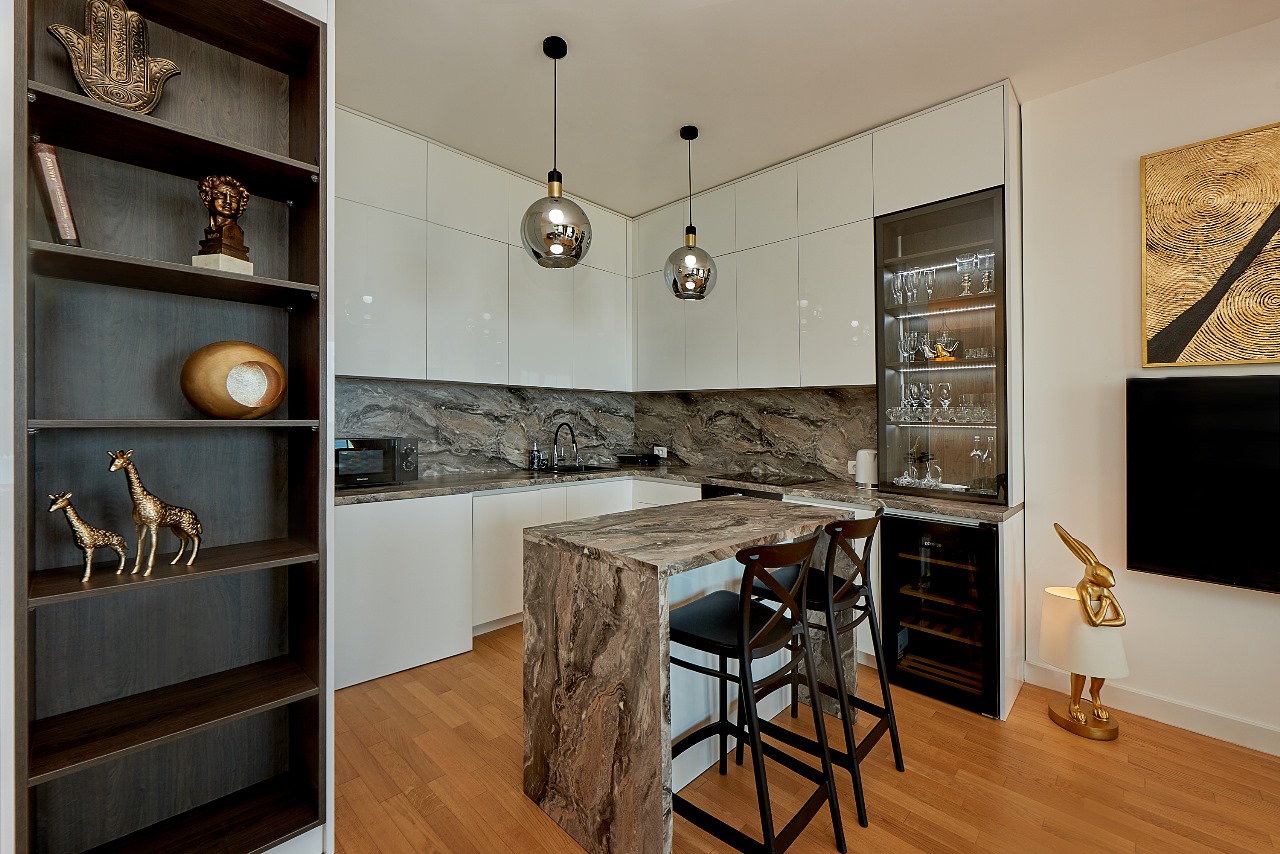 Modern kitchen with a marble bar counter and white cabinetry in an apartment, Becici, Montenegro.
