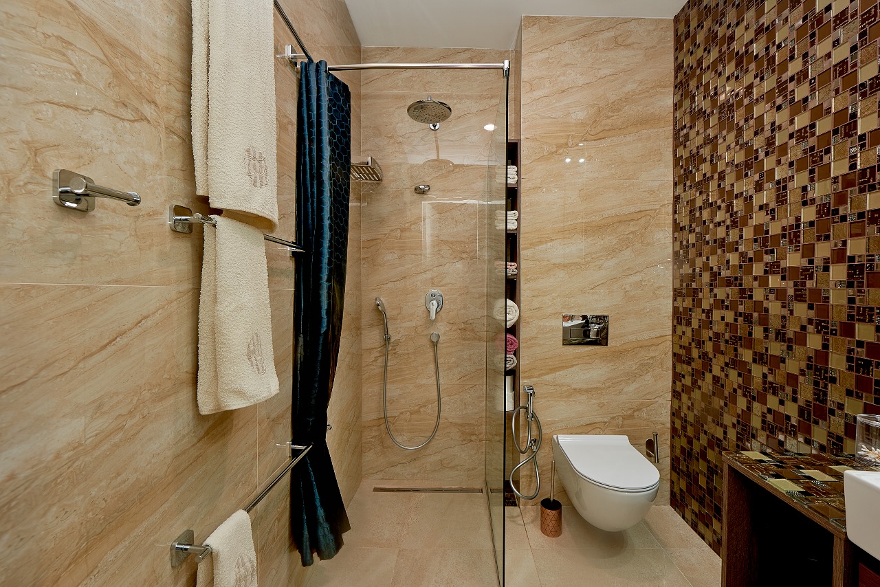 Modern bathroom in an apartment in Bečići, Montenegro: shower cabin, beige tiles, and mosaic decor.