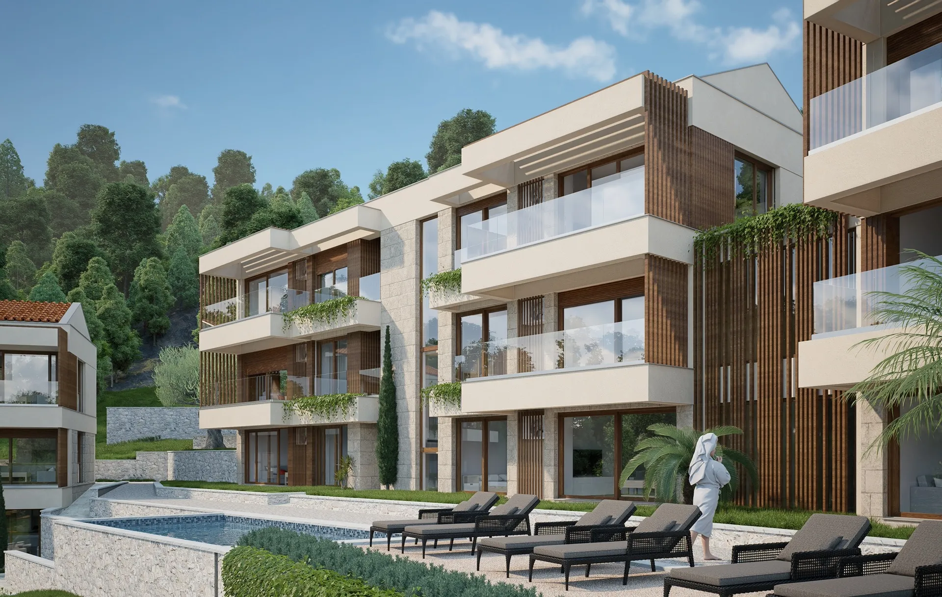Modern residential complex with a pool and terraces against a forested hill backdrop.