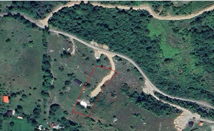 Top view of a land plot in Kolašin, Montenegro: property boundaries with an access road and forest landscape.
