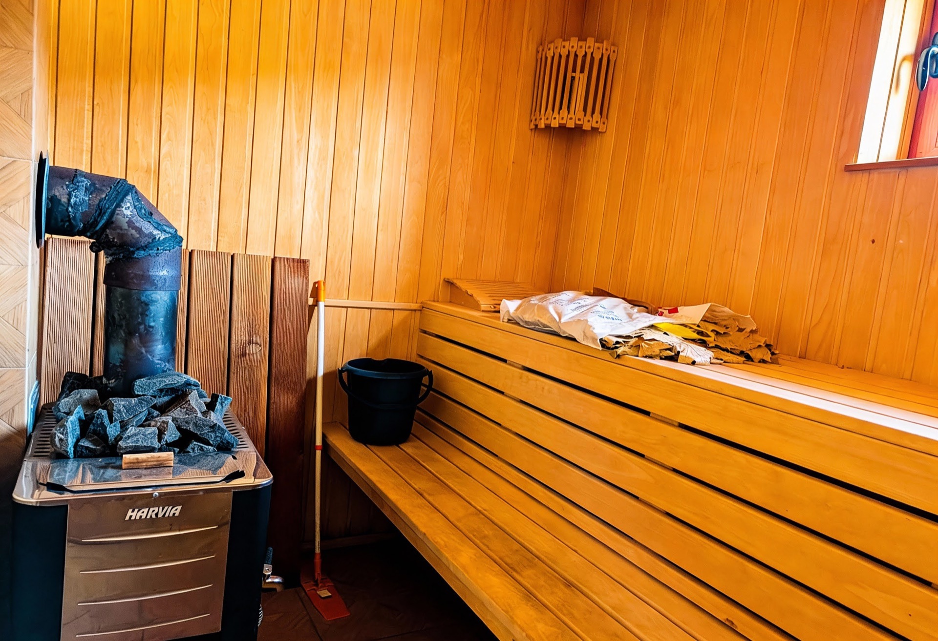 Wooden sauna with a Harvia stove at a villa in Luštica Bay, Montenegro: tongue-and-groove paneling, benches, and sauna accessories.