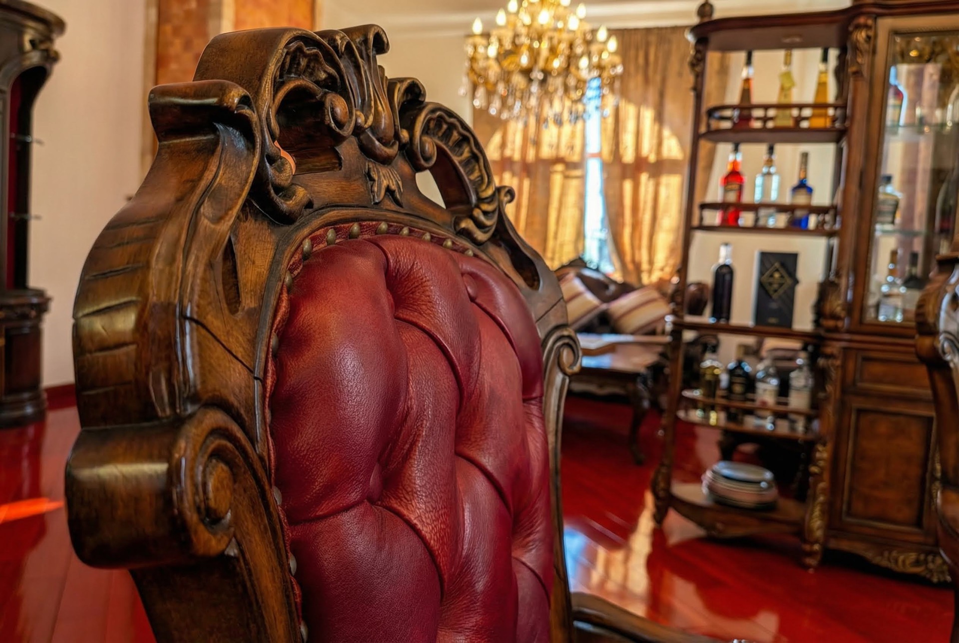 Living room interior in a villa in Luštica, Montenegro: a carved dark wood armchair with red leather upholstery.