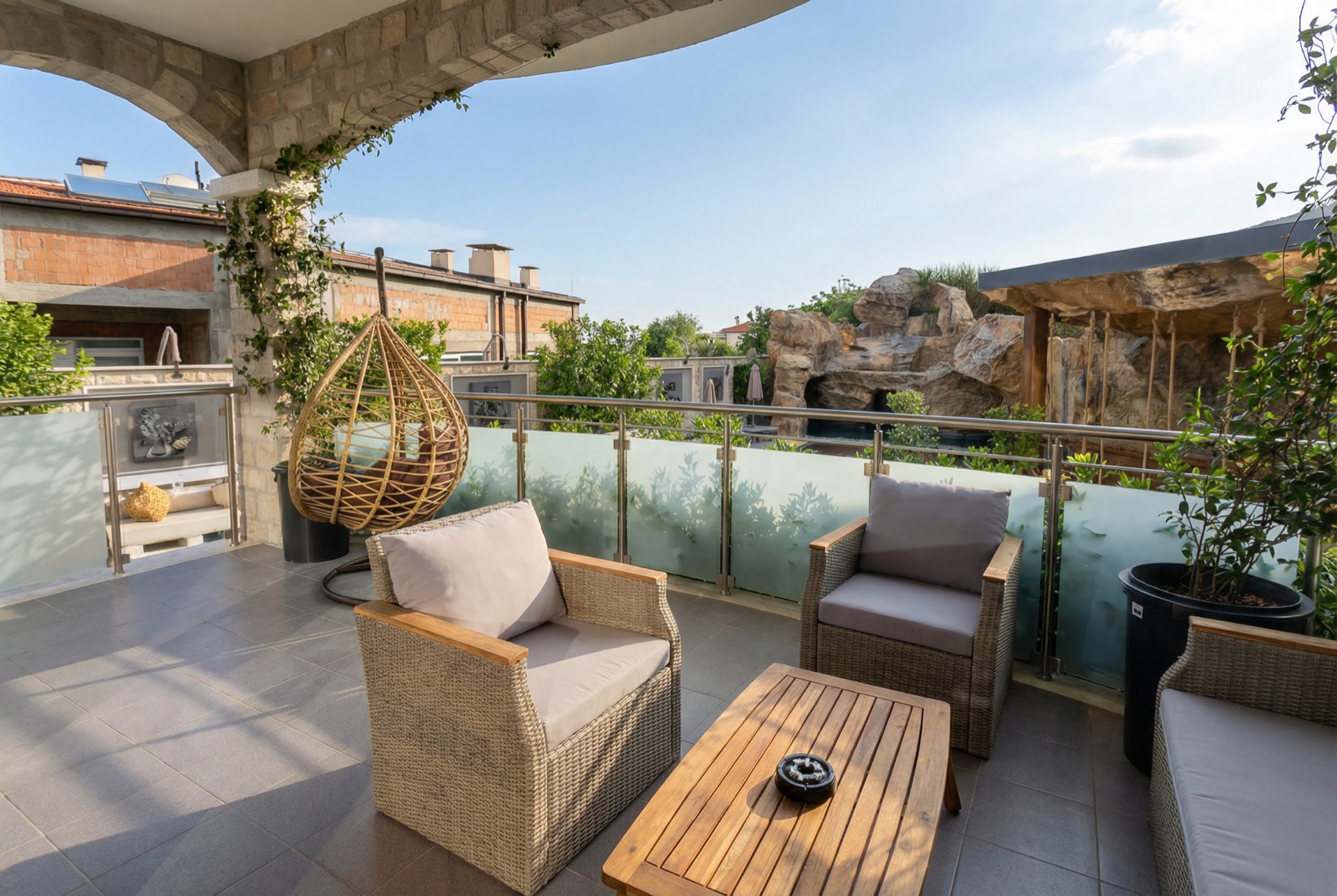 Cozy terrace with wicker furniture and a view of the cliffs in an apartment in Bečići, Montenegro.