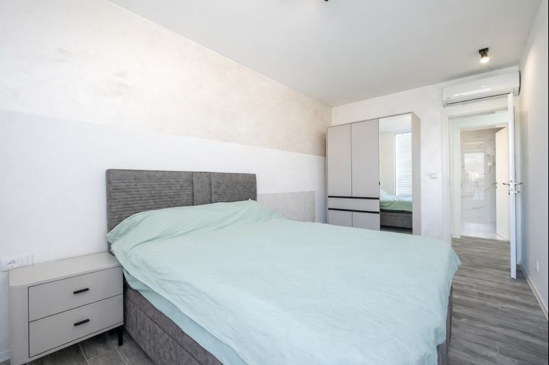 Bright bedroom with a double bed, wardrobe, and nightstand in a townhouse in Luštica, Montenegro.