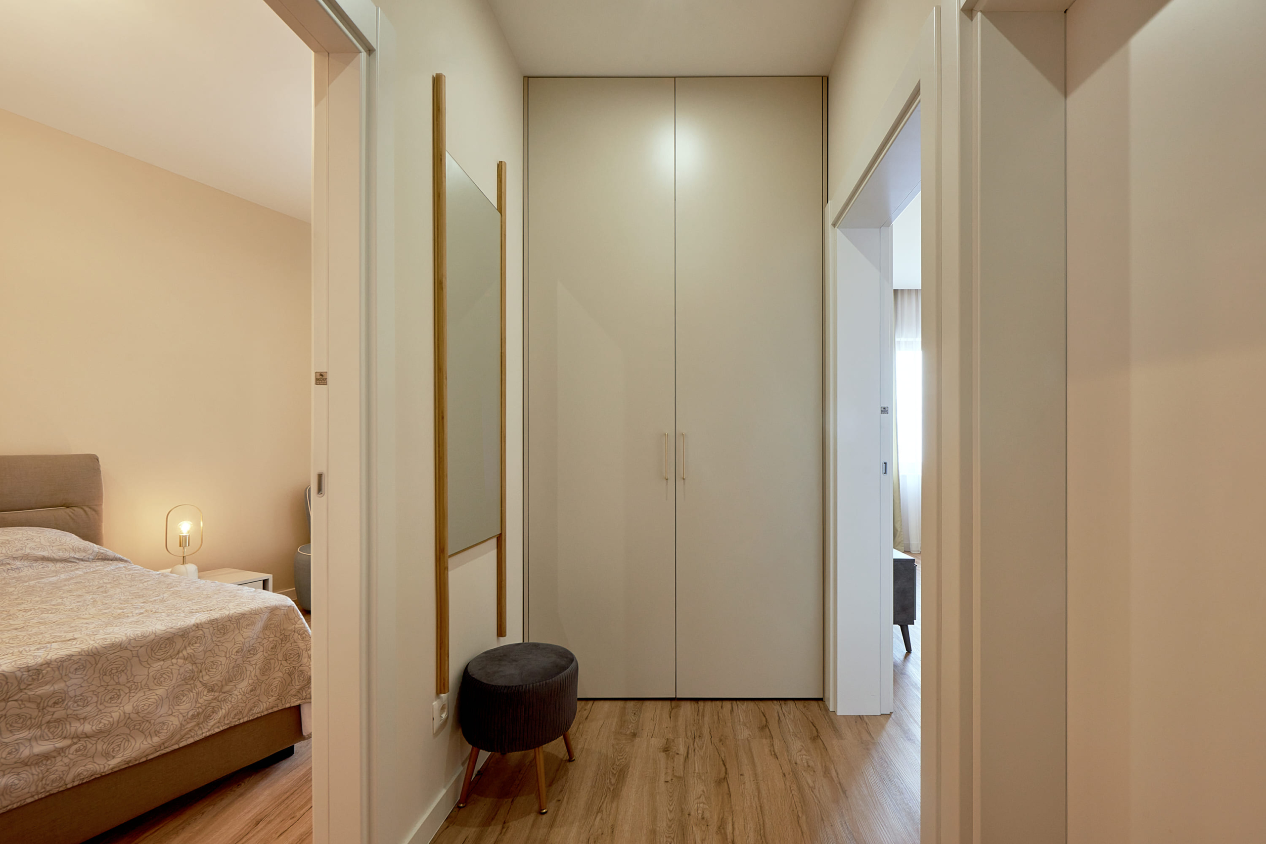 Bright hallway with a built-in wardrobe and mirror in an apartment in Bečići, Montenegro. View of a cozy bedroom.