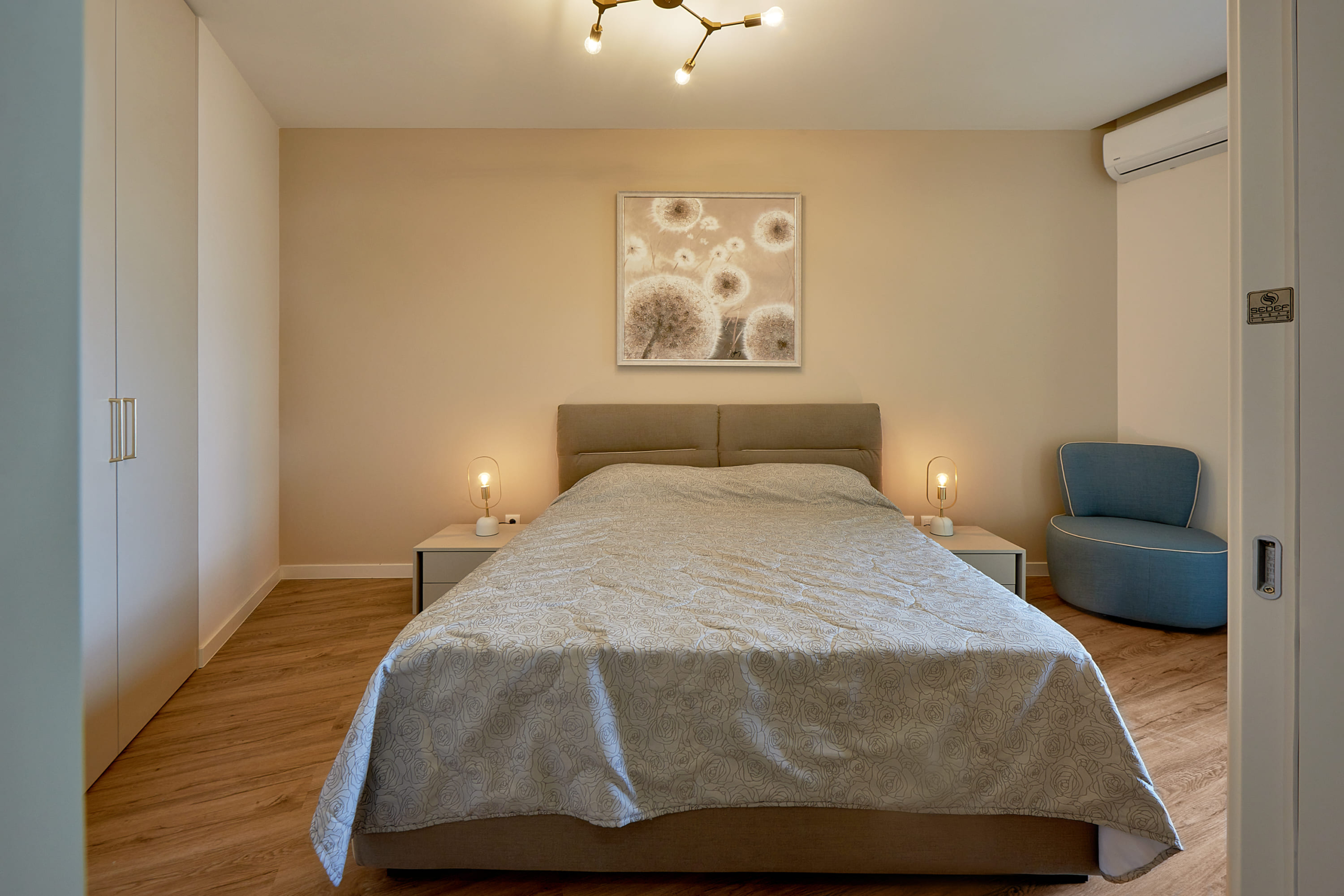 Modern bedroom with a double bed in Bečići apartments, Montenegro: stylish interior and cozy furniture.