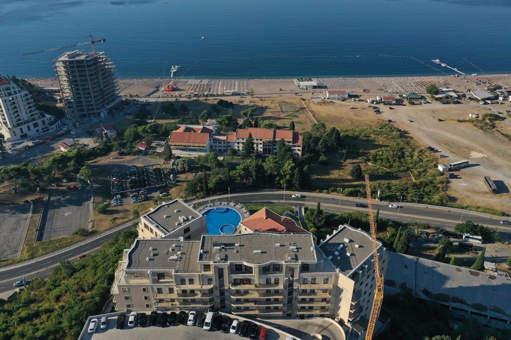 Aerial view of a residential complex with a pool in Bečići, Montenegro, near the beach and coastline.