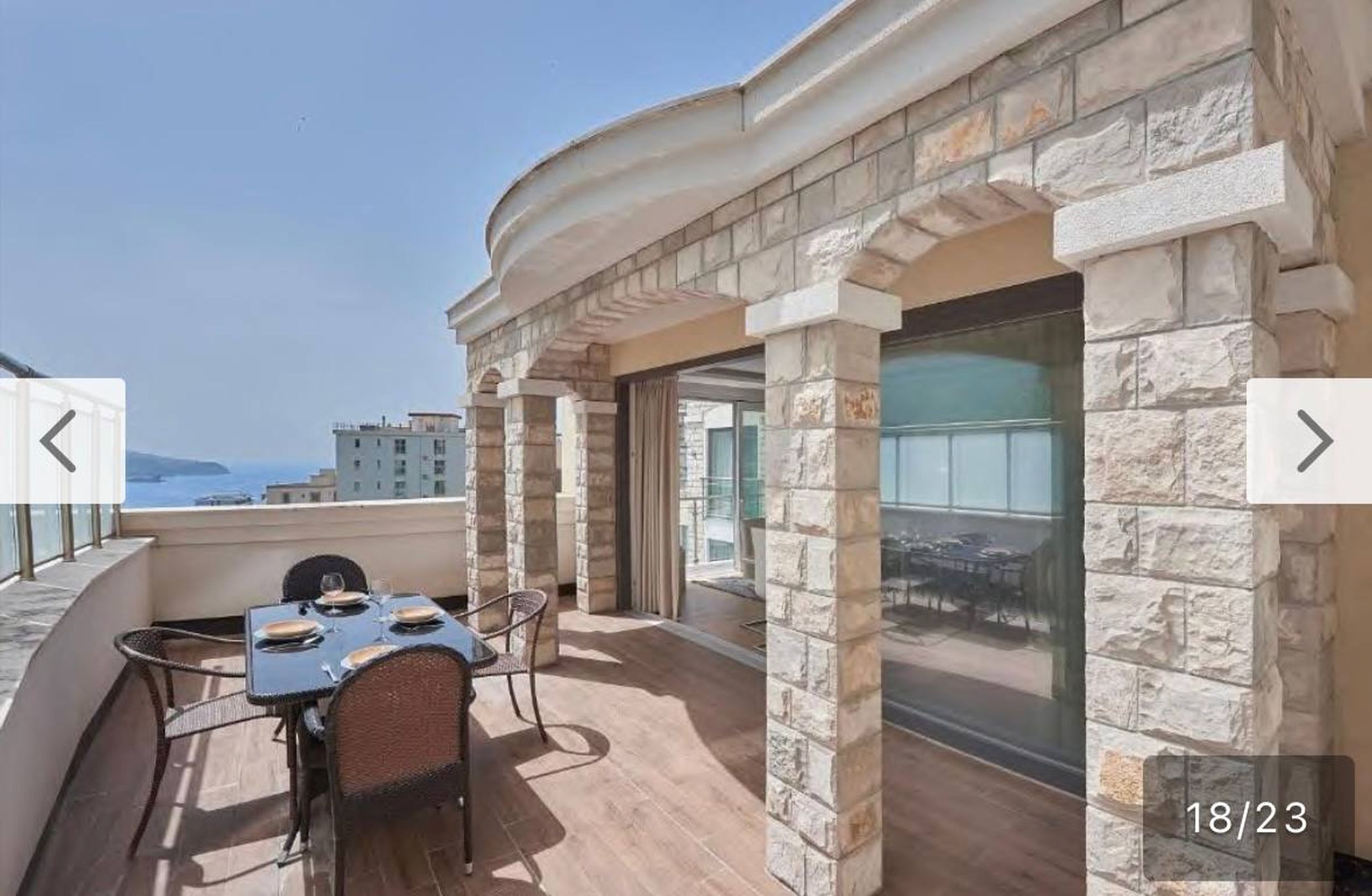 Terrace with stone columns and sea view in apartments, Bečići, Montenegro: outdoor dining area.