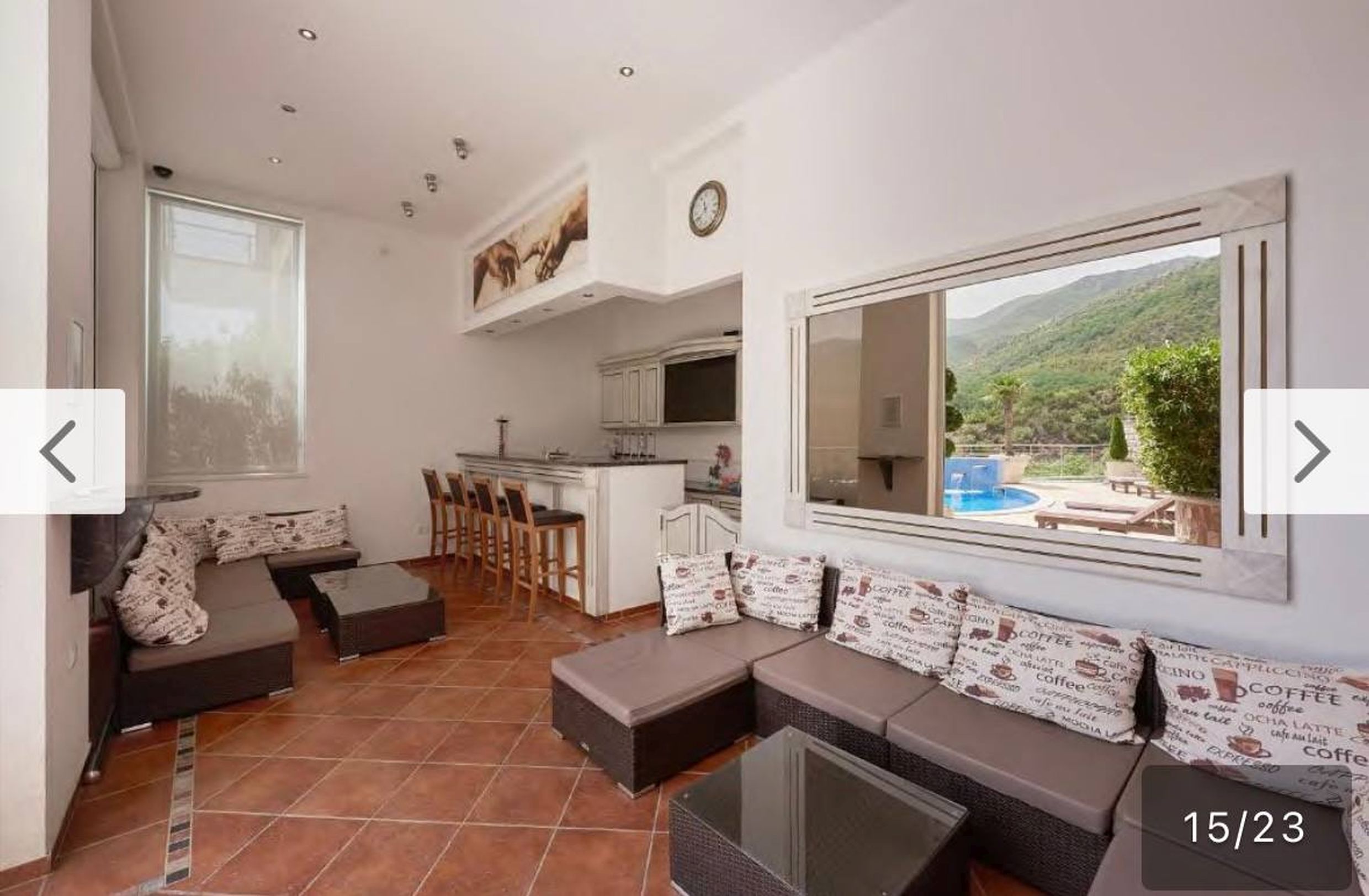 Living room with a bar counter and pool access in an apartment in Bečići, Montenegro: modern furniture and mountain view.
