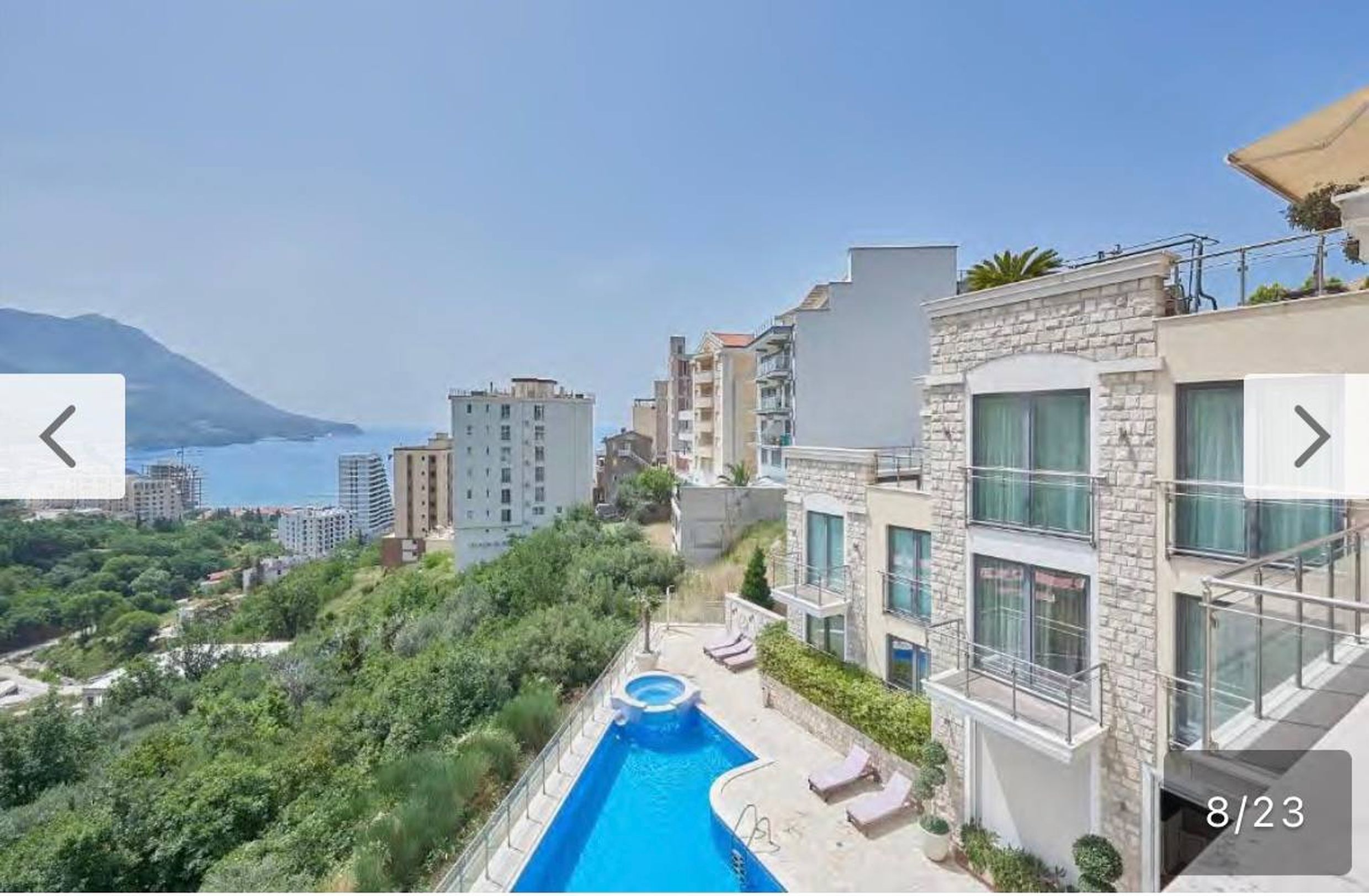 Apartment in Bečići, Montenegro: view of the pool, terrace, and panorama of the Adriatic Sea from the mountainside.