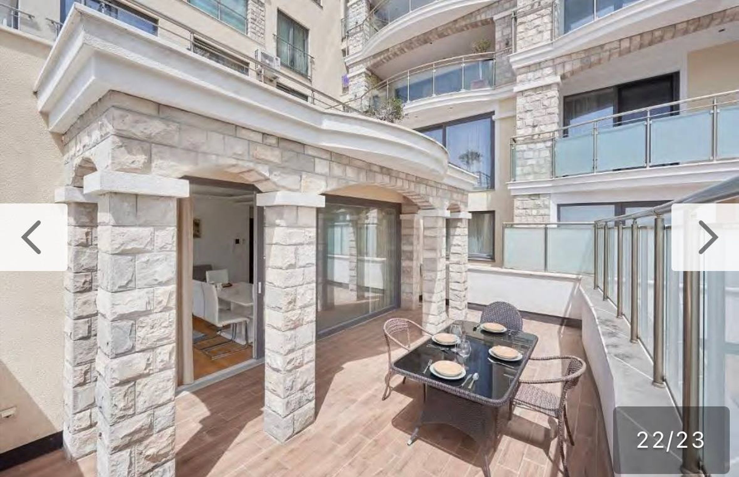 Spacious terrace with stone columns and dining area in the apartments, Bečići, Montenegro.