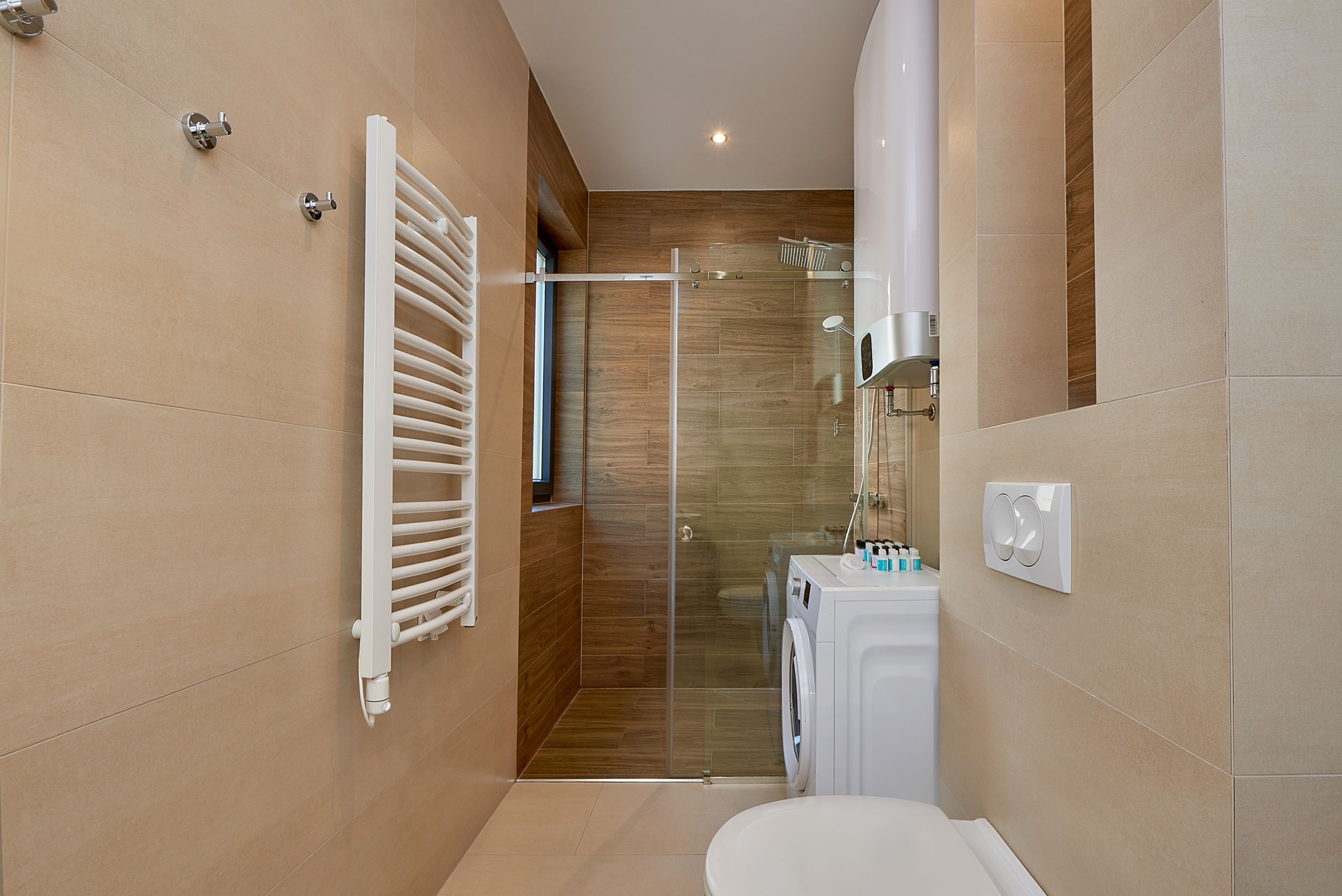 Modern bathroom with a shower cabin and washing machine in an apartment, Bečići, Montenegro.
