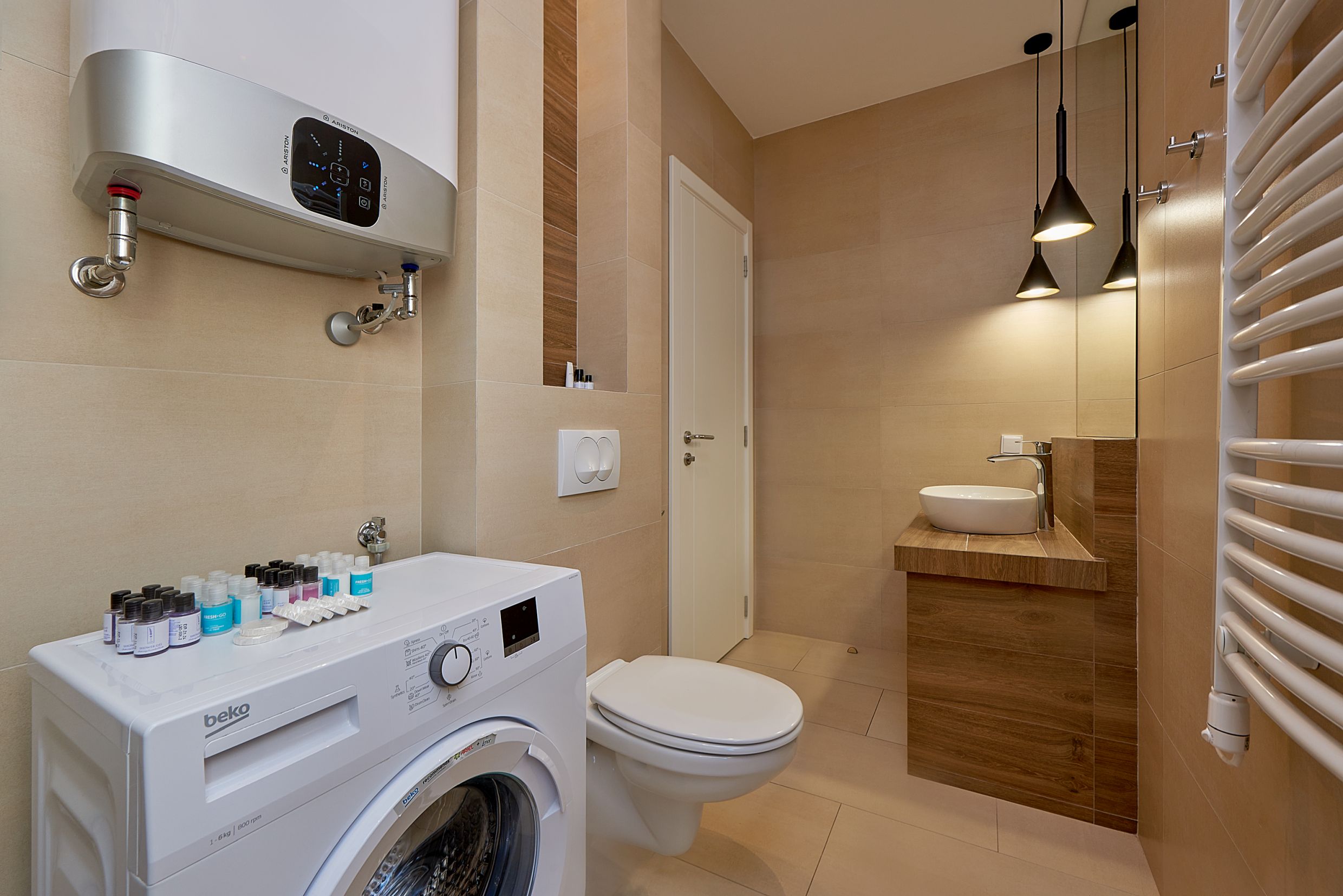 Modern bathroom with a shower and washing machine in an apartment in Bečići, Montenegro.