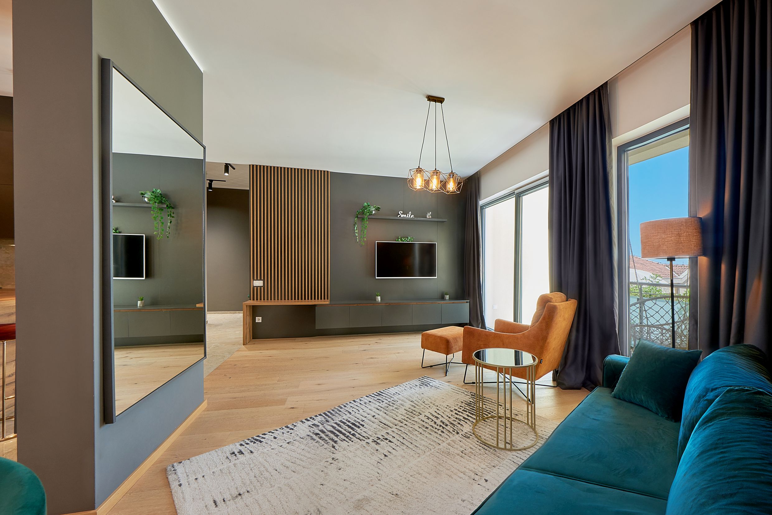 Modern living room in an apartment in Bečići, Montenegro: stylish furniture, wooden slats, and panoramic windows.