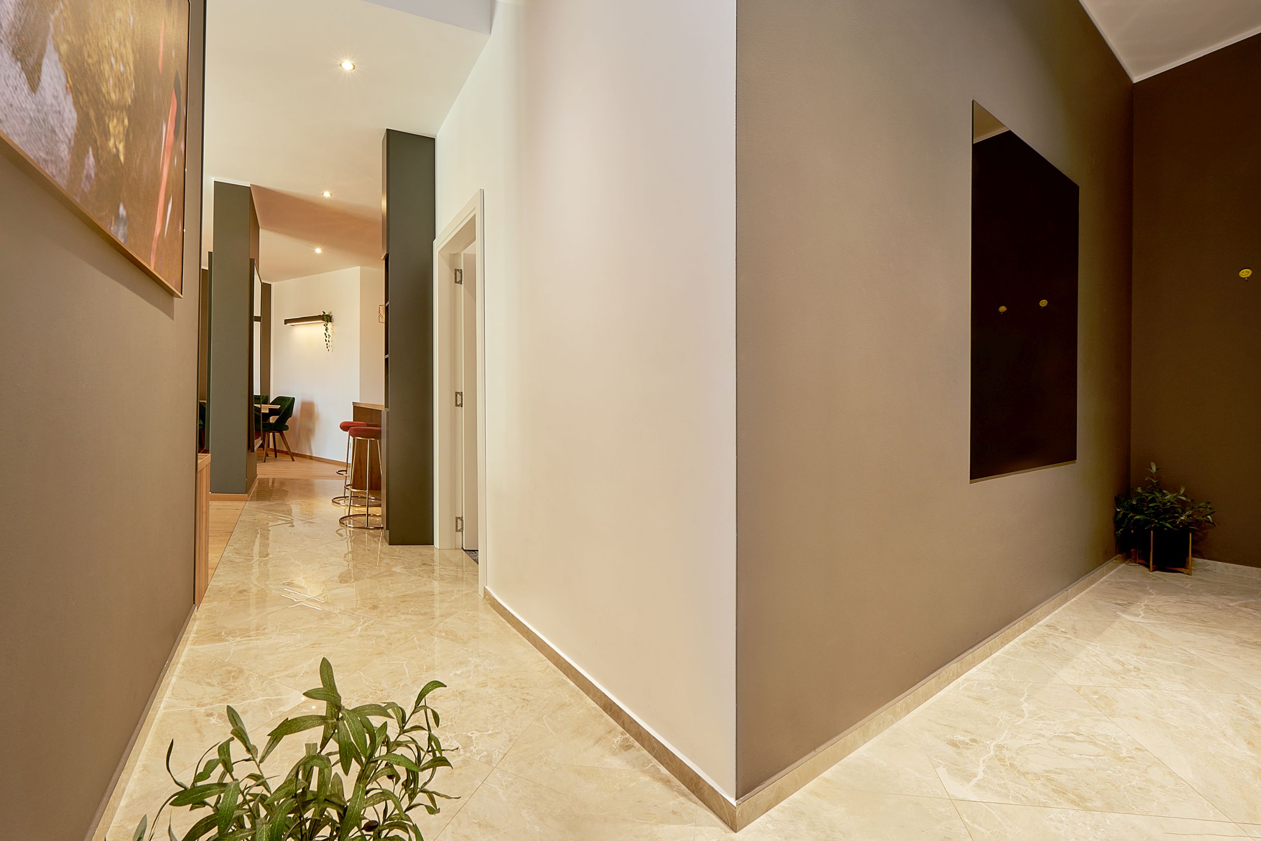 Modern hallway interior with marble flooring in an apartment, Bečići, Montenegro. View of the kitchen with a bar counter.