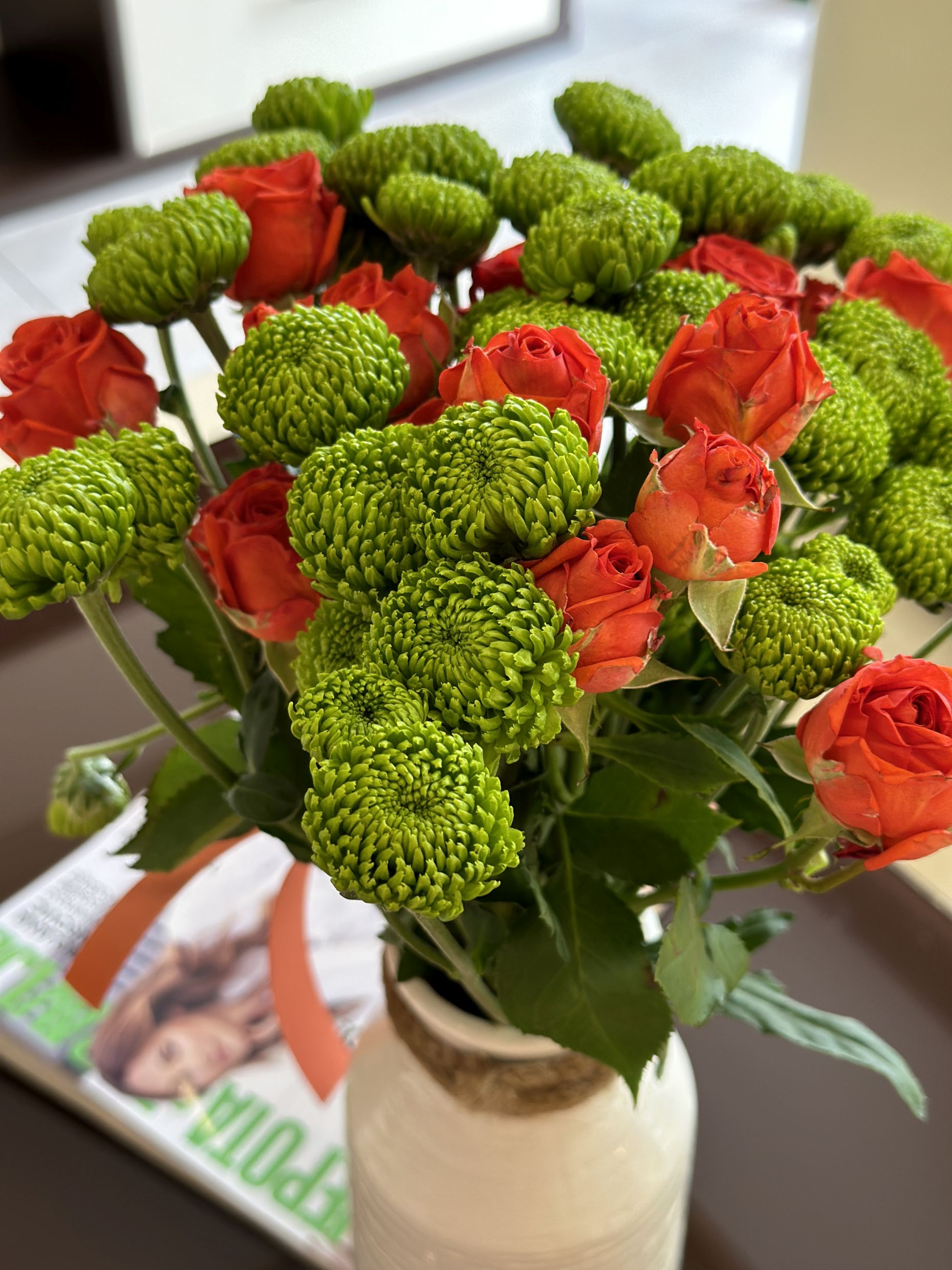 A bouquet of red roses and green chrysanthemums in a Bečići, Montenegro apartment interior, adding a cozy touch to the living space.