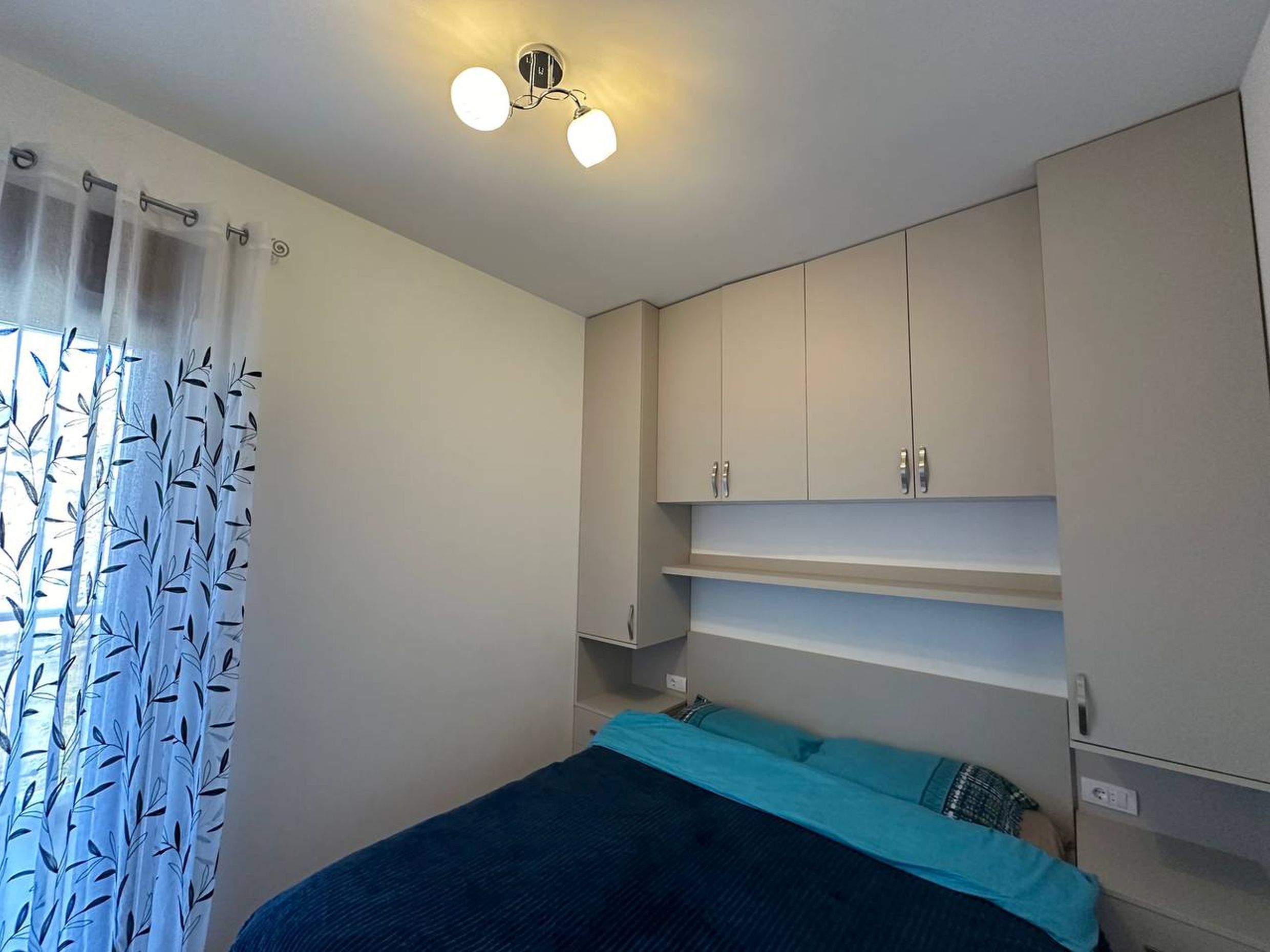 Bedroom in an apartment in Bečići, Montenegro: double bed, built-in wardrobe, and light interior finishes.