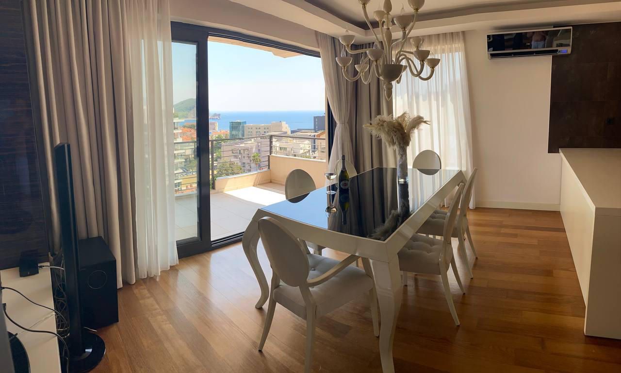 Living room with dining area and sea view in an apartment, Budva, Montenegro: modern interior and terrace.