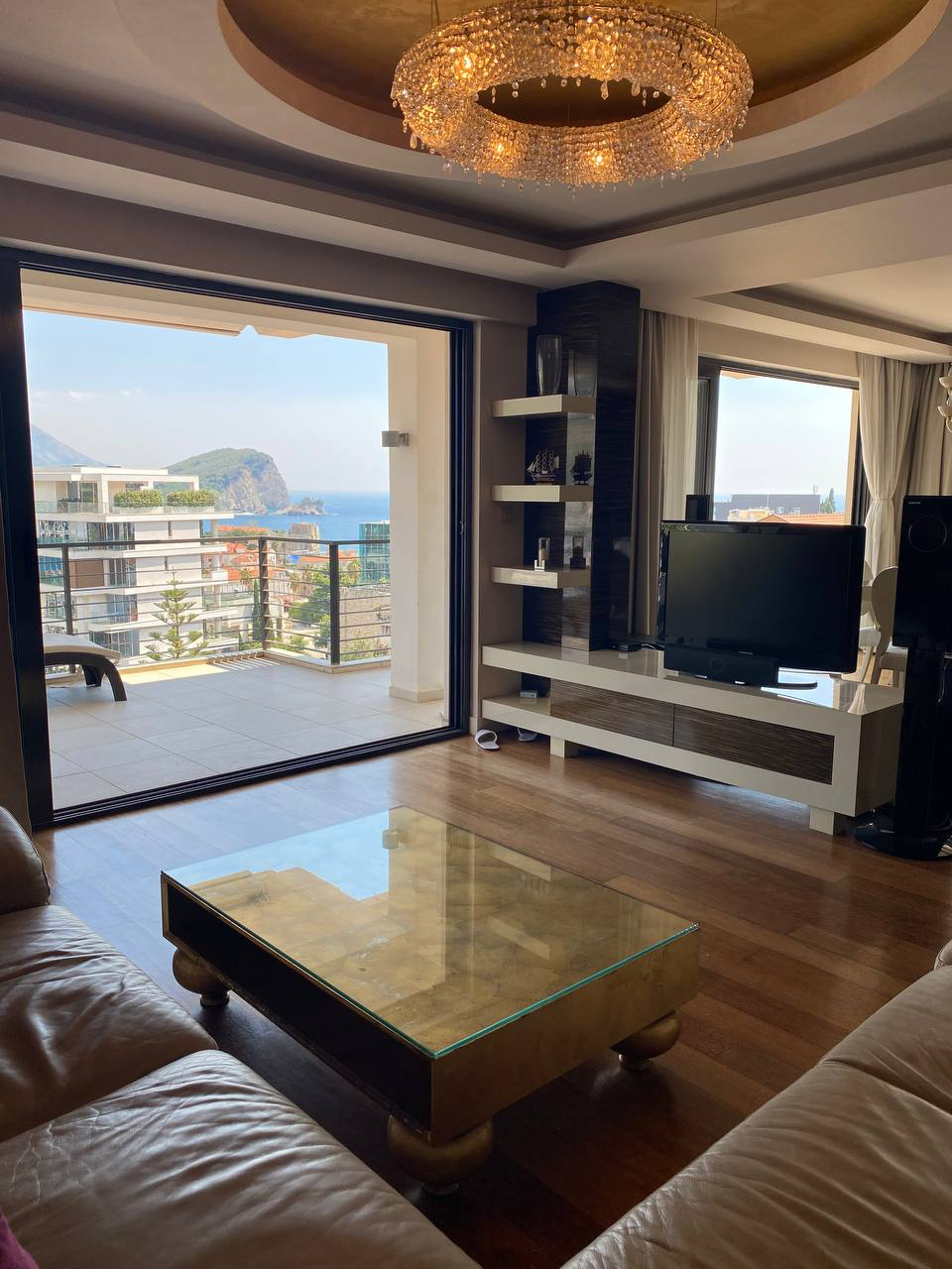 Living room in an apartment in Budva, Montenegro: panoramic sea view, terrace, leather furniture, and stylish interior.