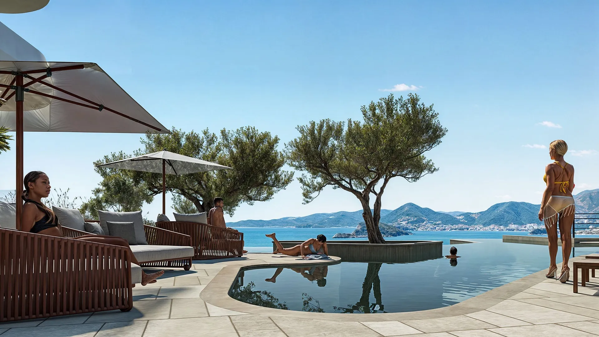 People relax by an infinity pool overlooking the sea and mountains. Wooden furniture, umbrellas, and olive trees are visible under a clear sky.