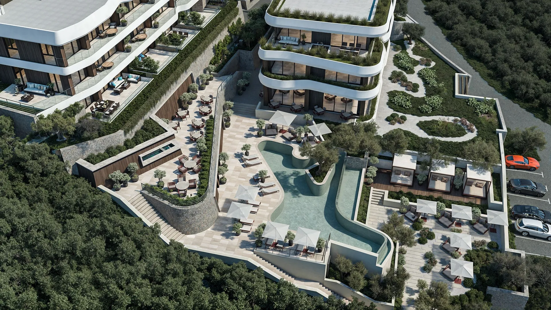 Aerial view of a modern complex featuring a winding pool, terraces with umbrellas, and lush greenery among trees.