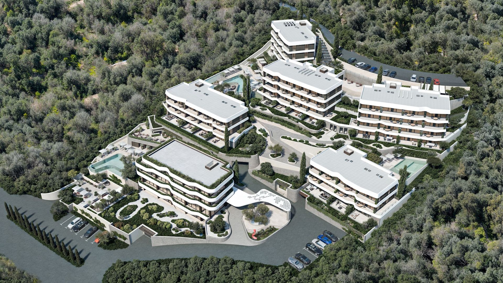 Top view of a modern residential complex in Reževići, Montenegro: low-rise buildings, swimming pools, and landscaping.