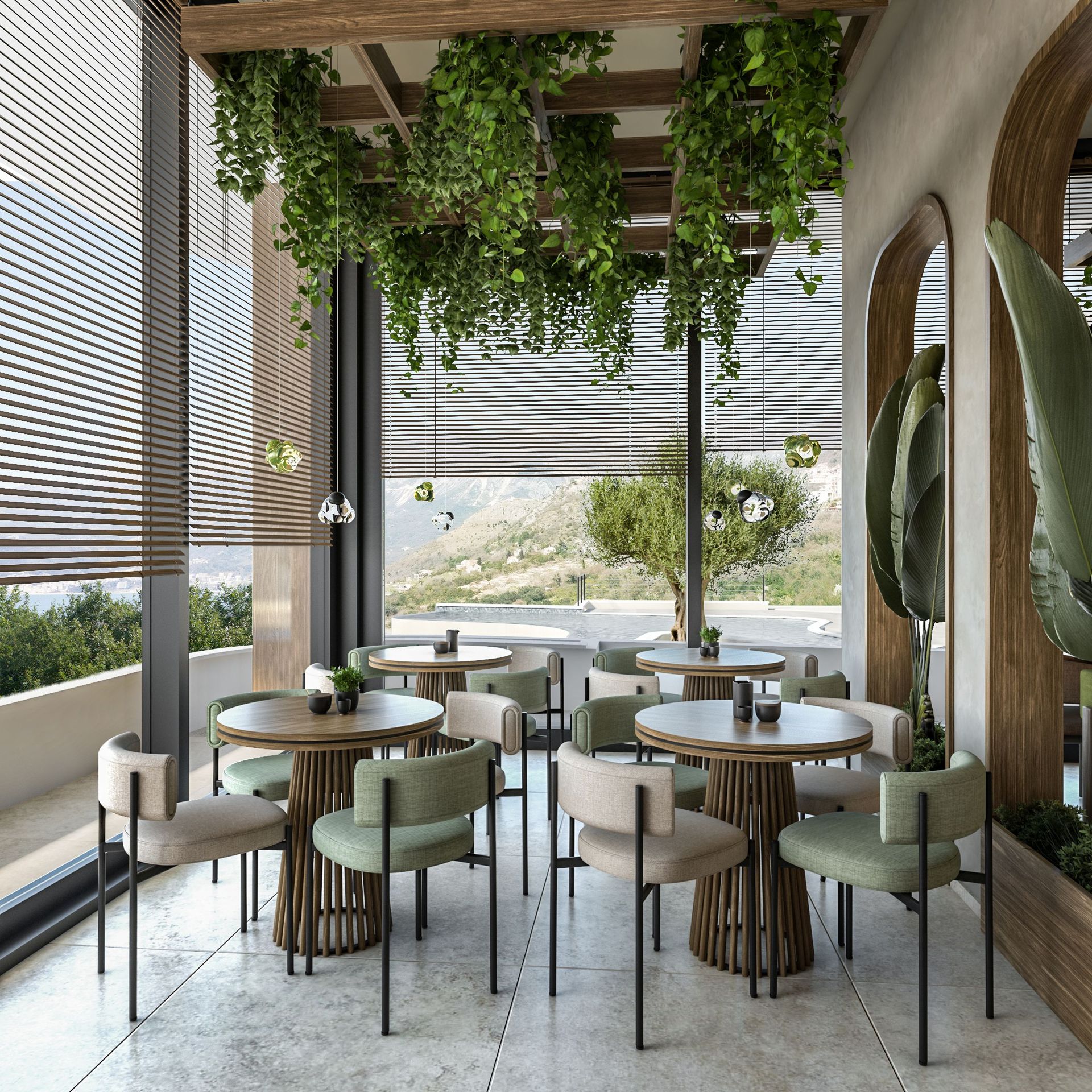 Designer restaurant terrace in the Rezevici residential complex, Montenegro: round tables, soft chairs, and a view of the mountains and sea.