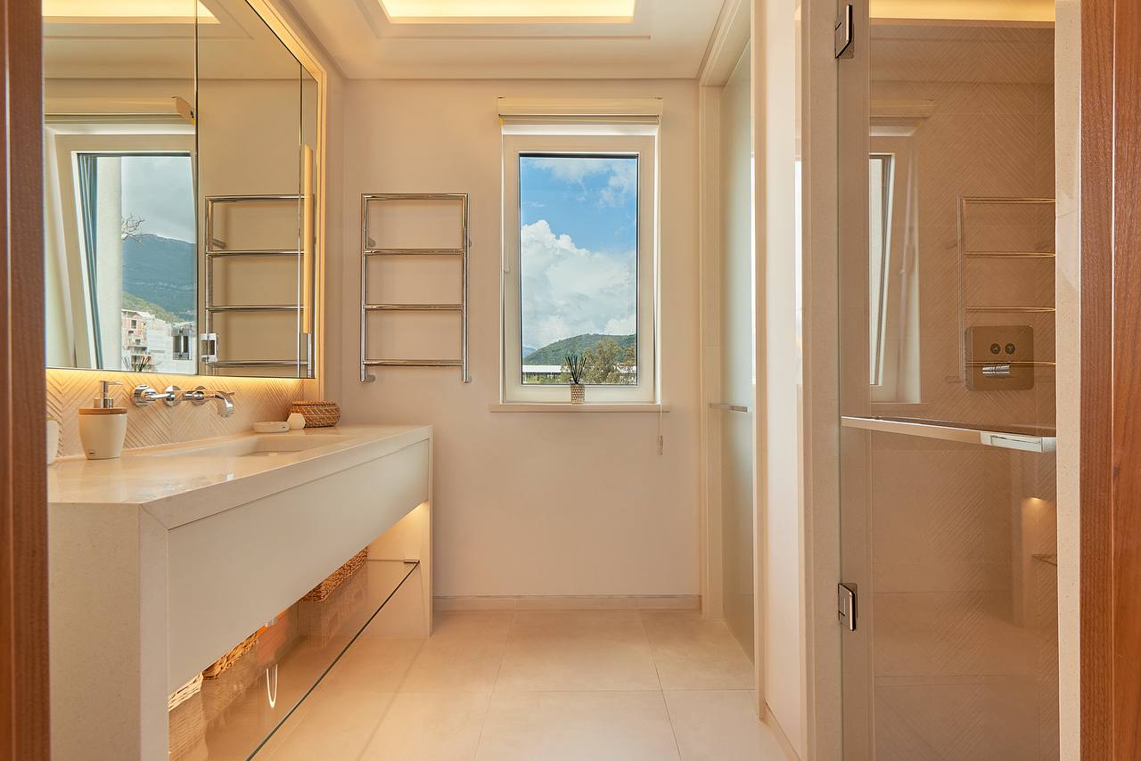 Modern bathroom in an apartment in Porto Montenegro, Tivat, Montenegro: light finishes, shower, and mountain view.