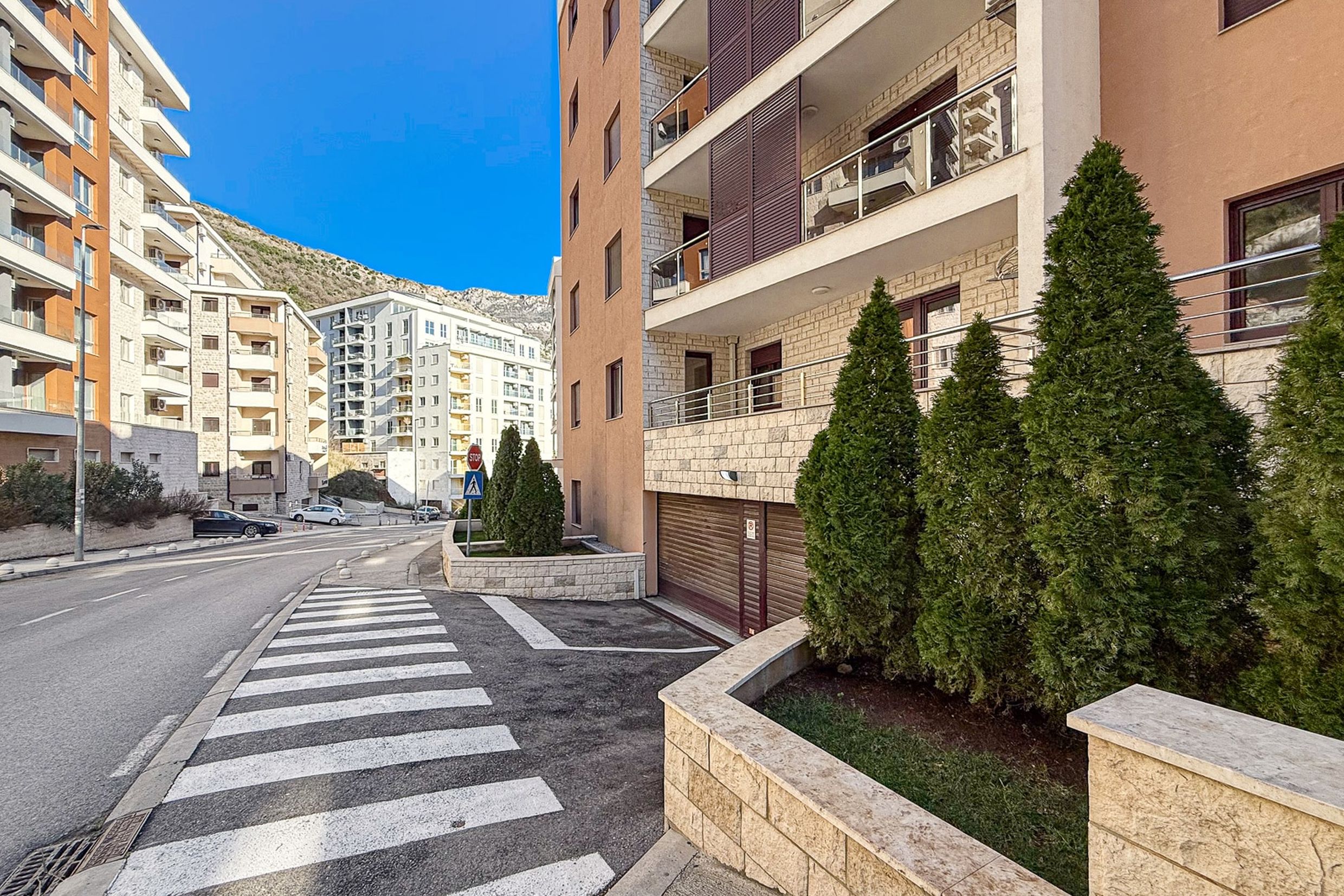 Modern residential complex with underground parking and landscaped grounds in Becici, Montenegro.